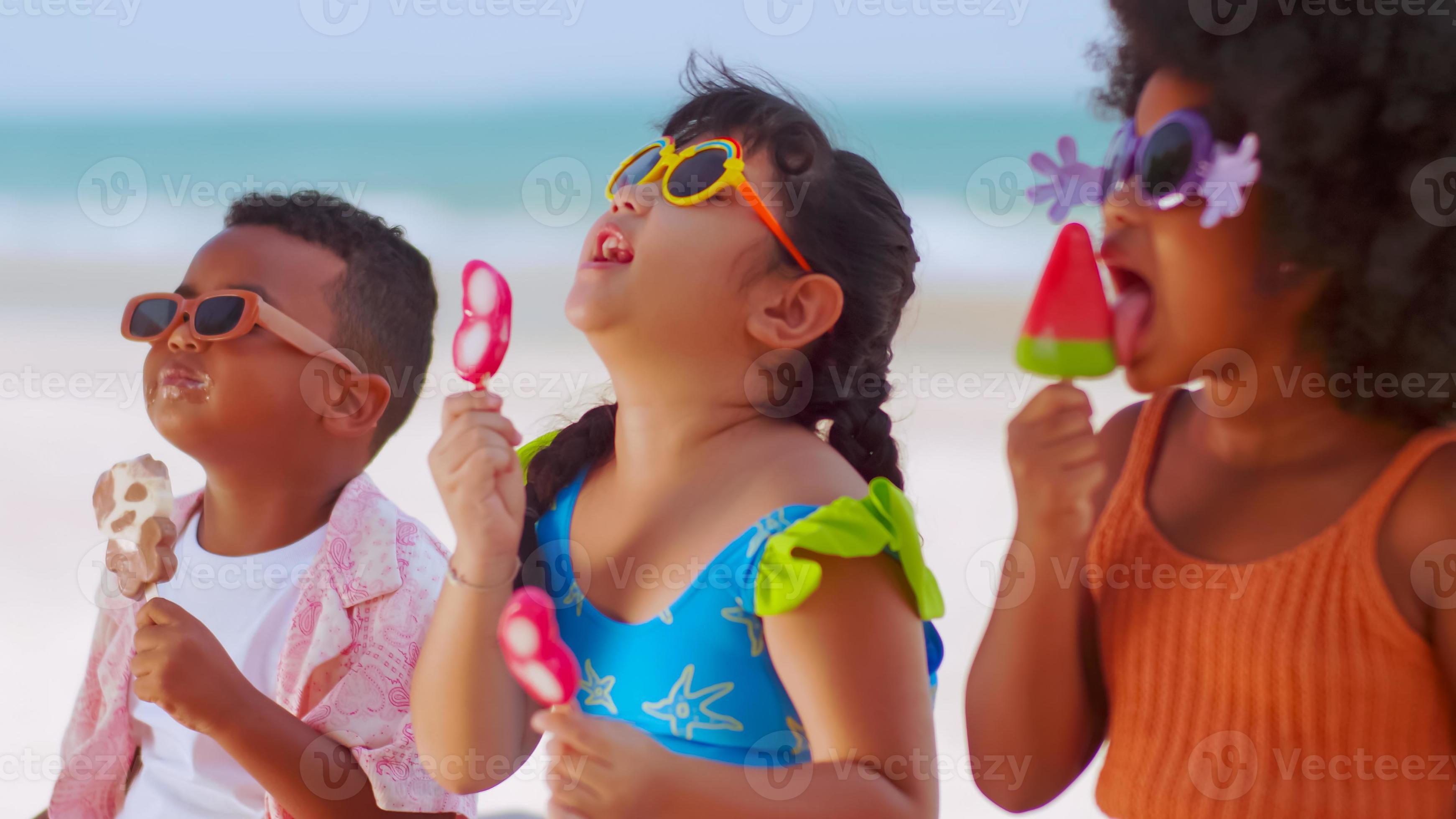 group-of-children-eating-ice-cream-while-having-a-picnic-on-the-beach