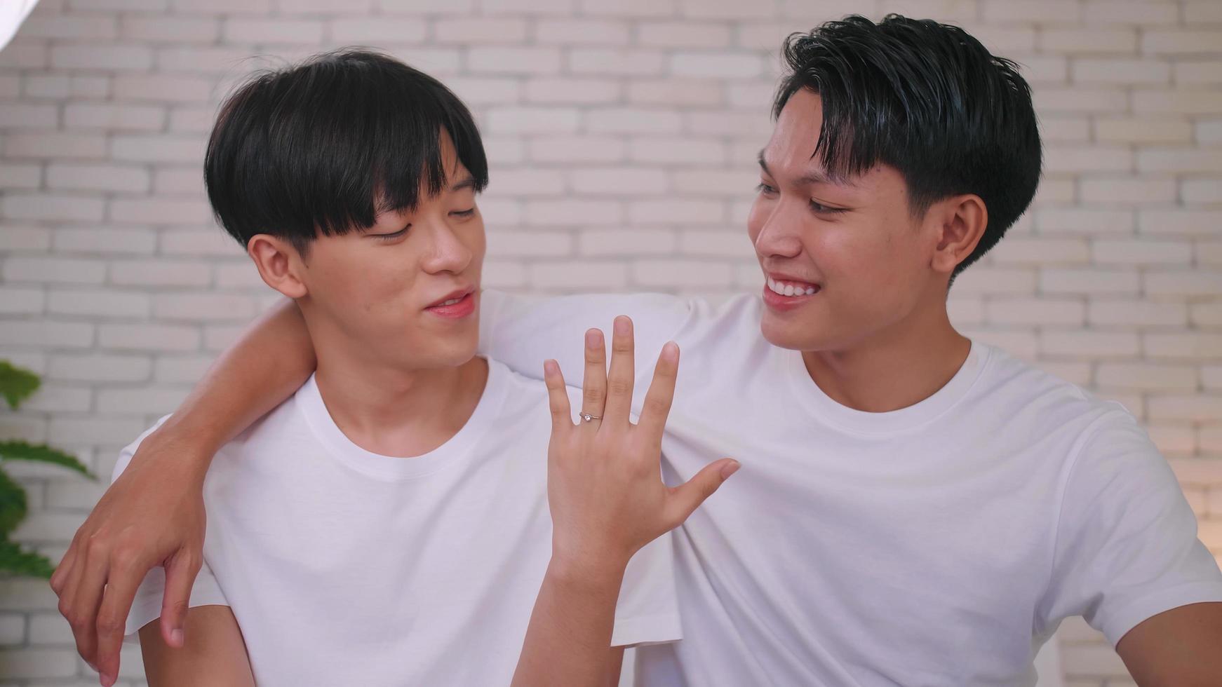 feliz pareja asiática gay mostrando su anillo de bodas. foto