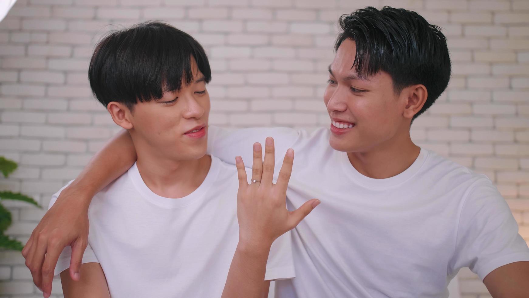 Happy gay Asian couple showing off their wedding ring. photo