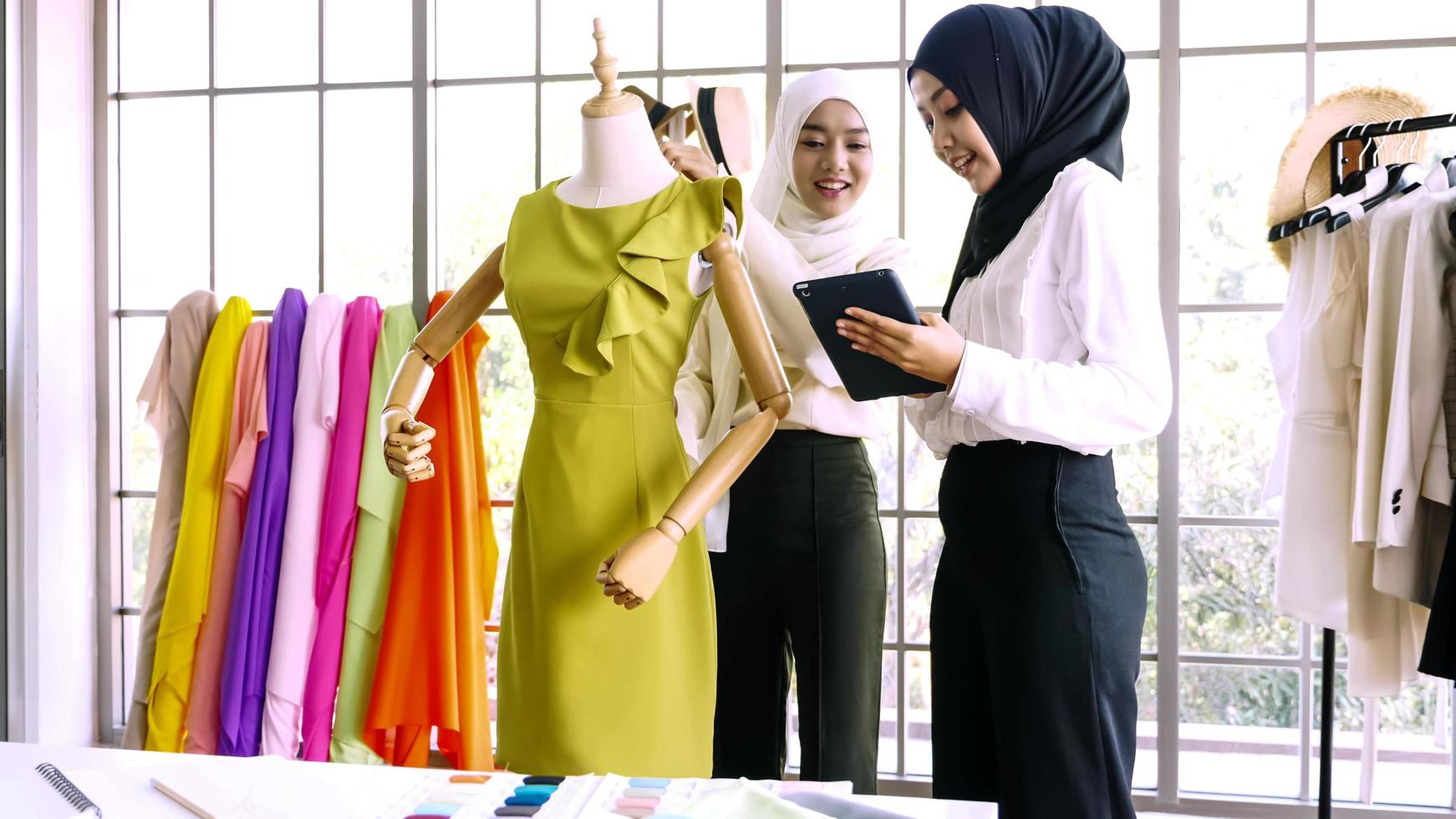 Beautiful muslim women working together at the clothing office. photo