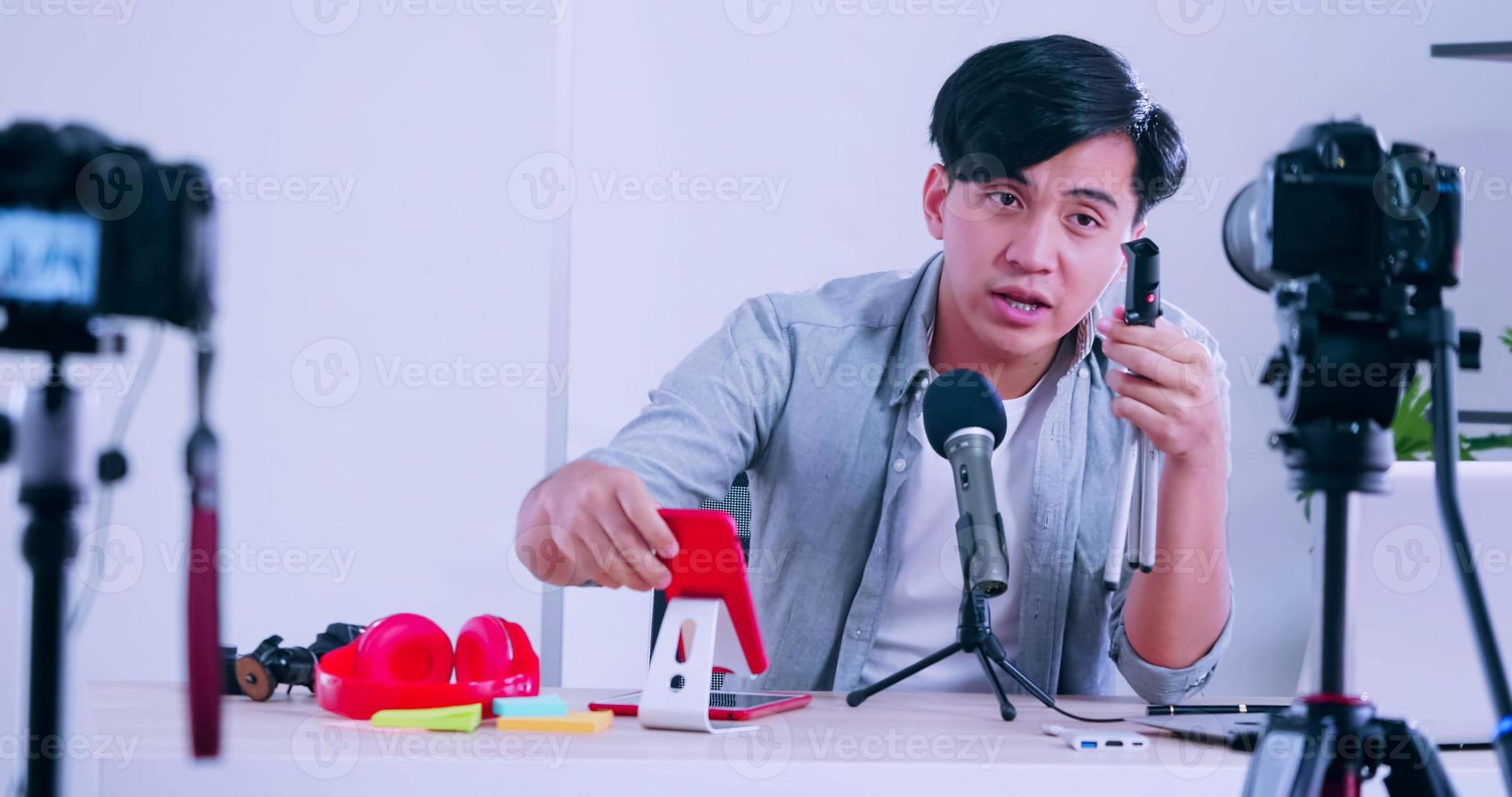 Young Asia man selling digital gadgets on social media by streaming live from his home. photo