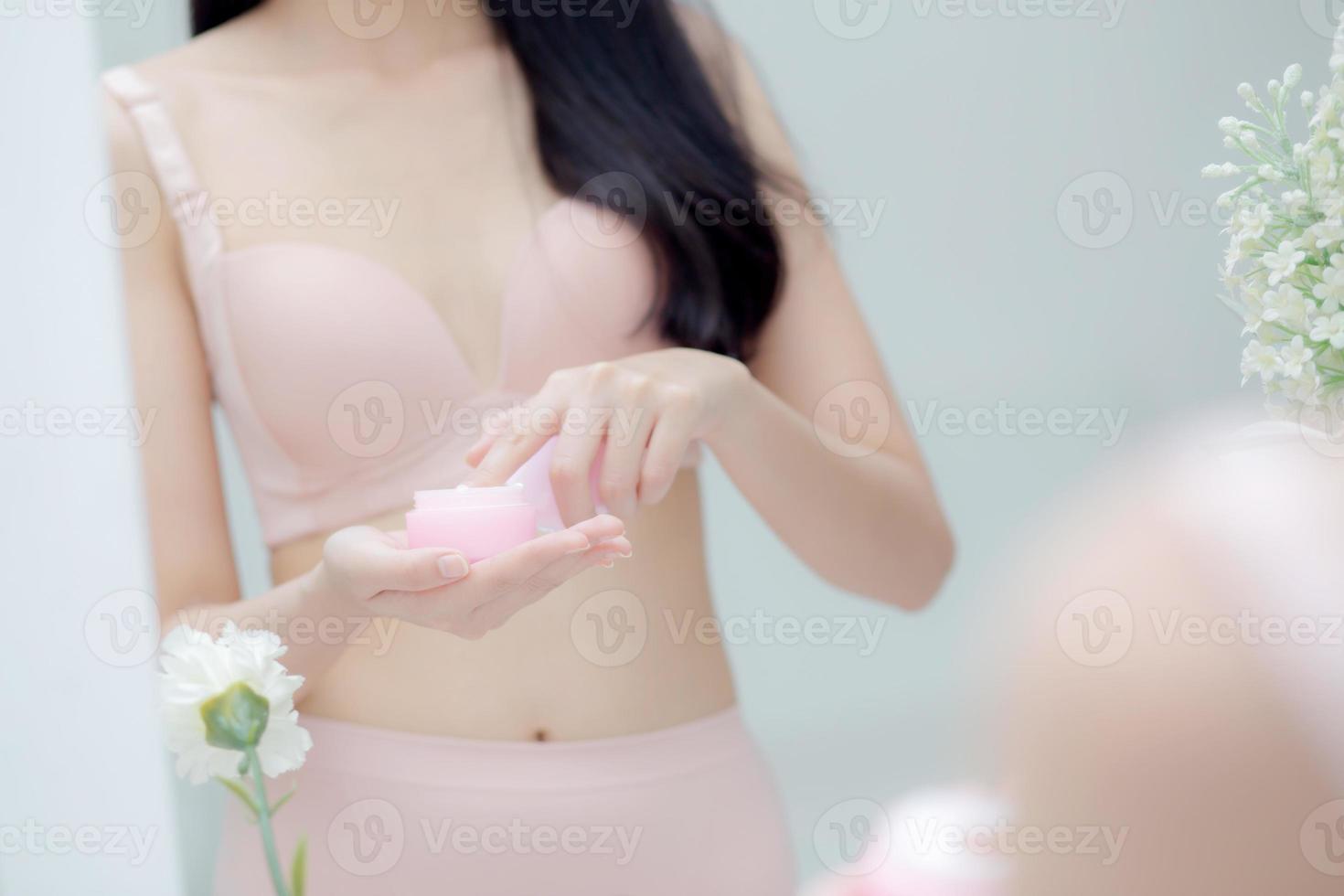 Closeup hand of young asian woman holding product cosmetic applying cream in jar, beautiful girl hand touch lotion for rejuvenation, beauty perfect, treatment and skin care and health concept. photo