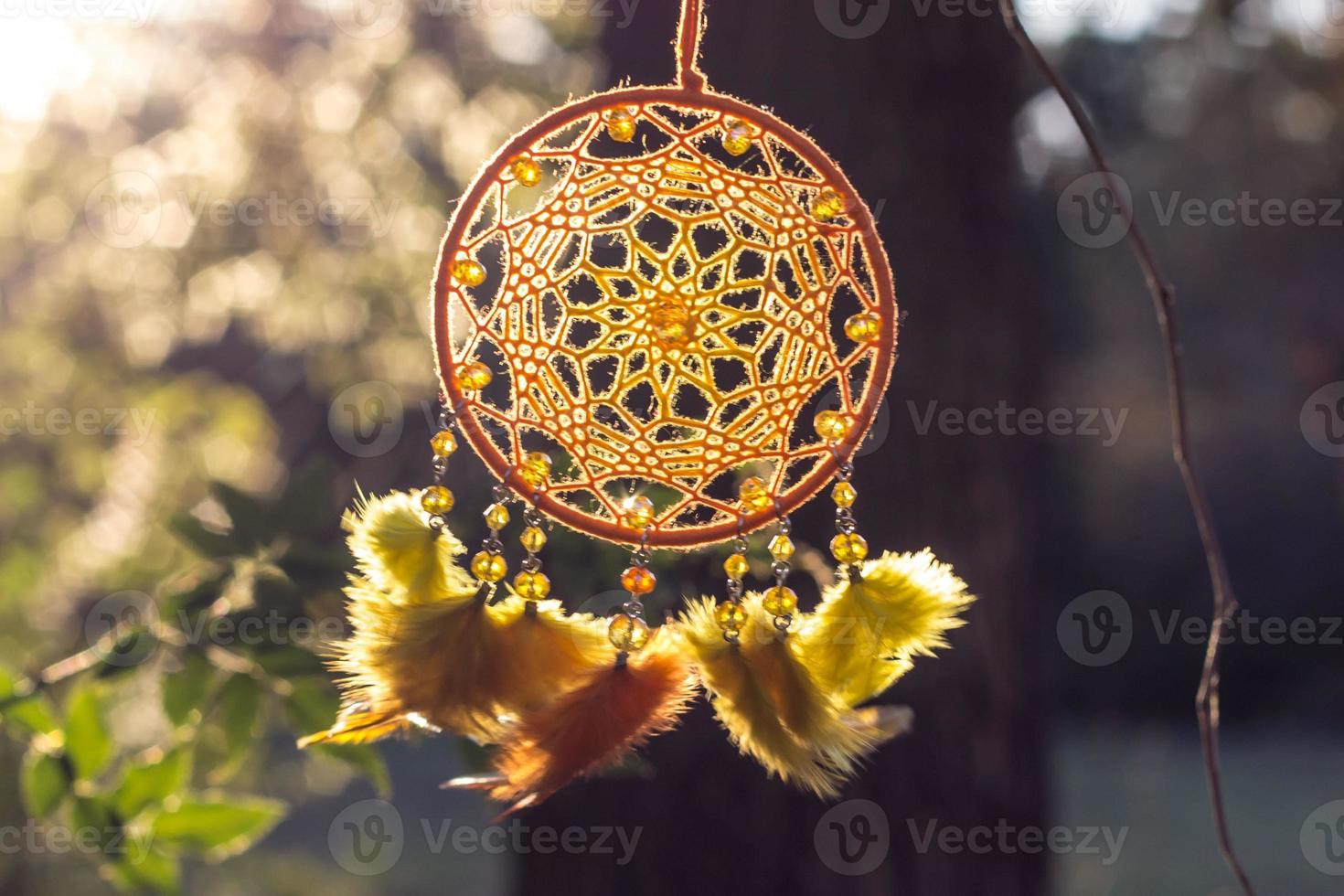 atrapasueños hecho a mano con hilos de plumas y cuerda de cuentas colgando foto