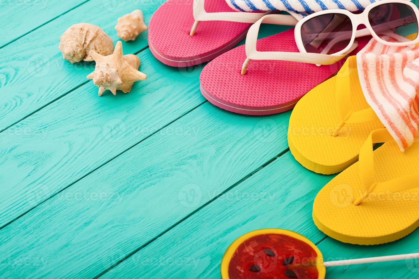 Flip flops, towels and watermelon summer candy food on blue wooden background. Top view. Mock up. Copy space. Sweet Lollipop. Selective focus photo