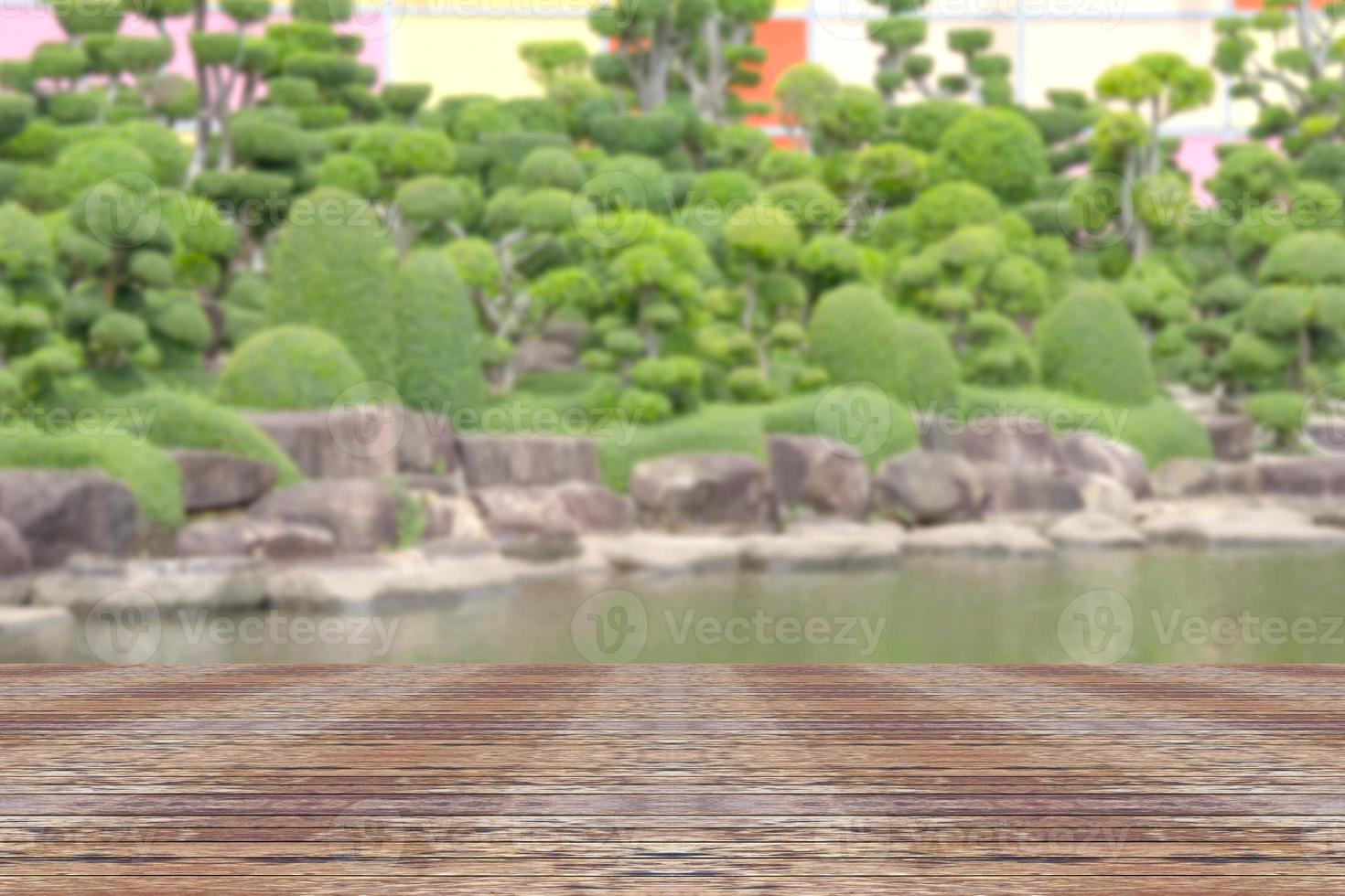 Top desk with blur bonsai trees background,wooden table photo