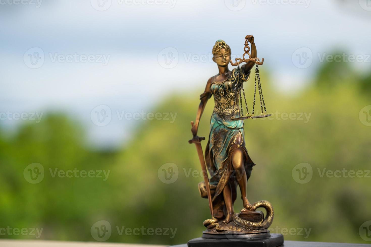 estatua de themis contra un fondo de naturaleza. símbolo de justicia y ley, crimen y castigo. foto