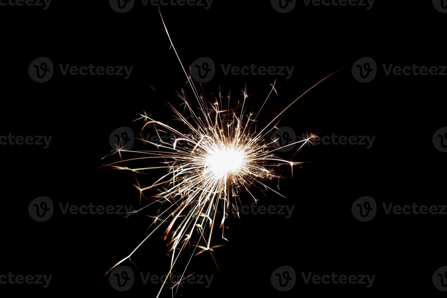 Burning sparkler isolated on black background. Fireworks theme. Light effect and texture. photo