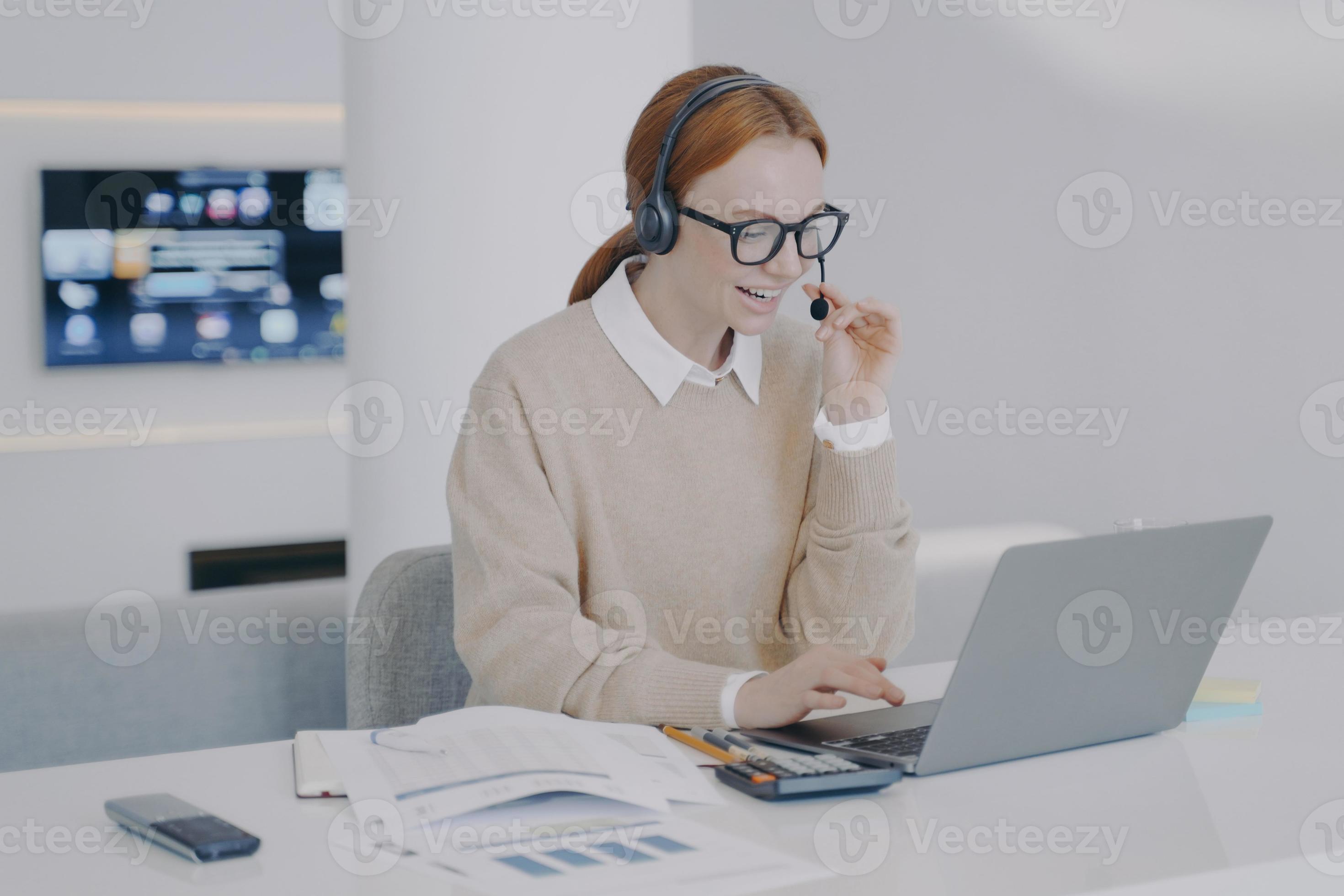 Distance online interpreter girl in headset talking to client at pc