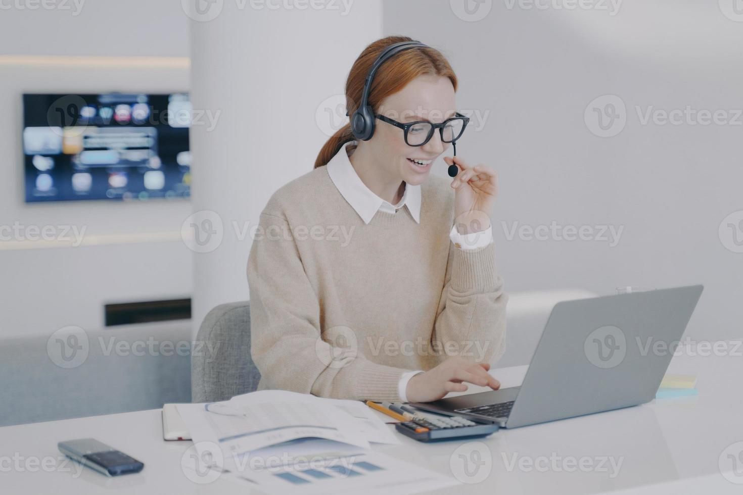Distance online interpreter. Girl in headset talking to client at PC. Service and customer support. photo