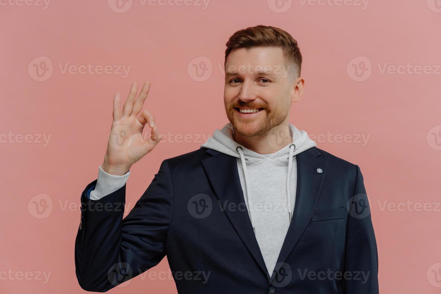 Handsome positive man showing ok gesture with finger photo