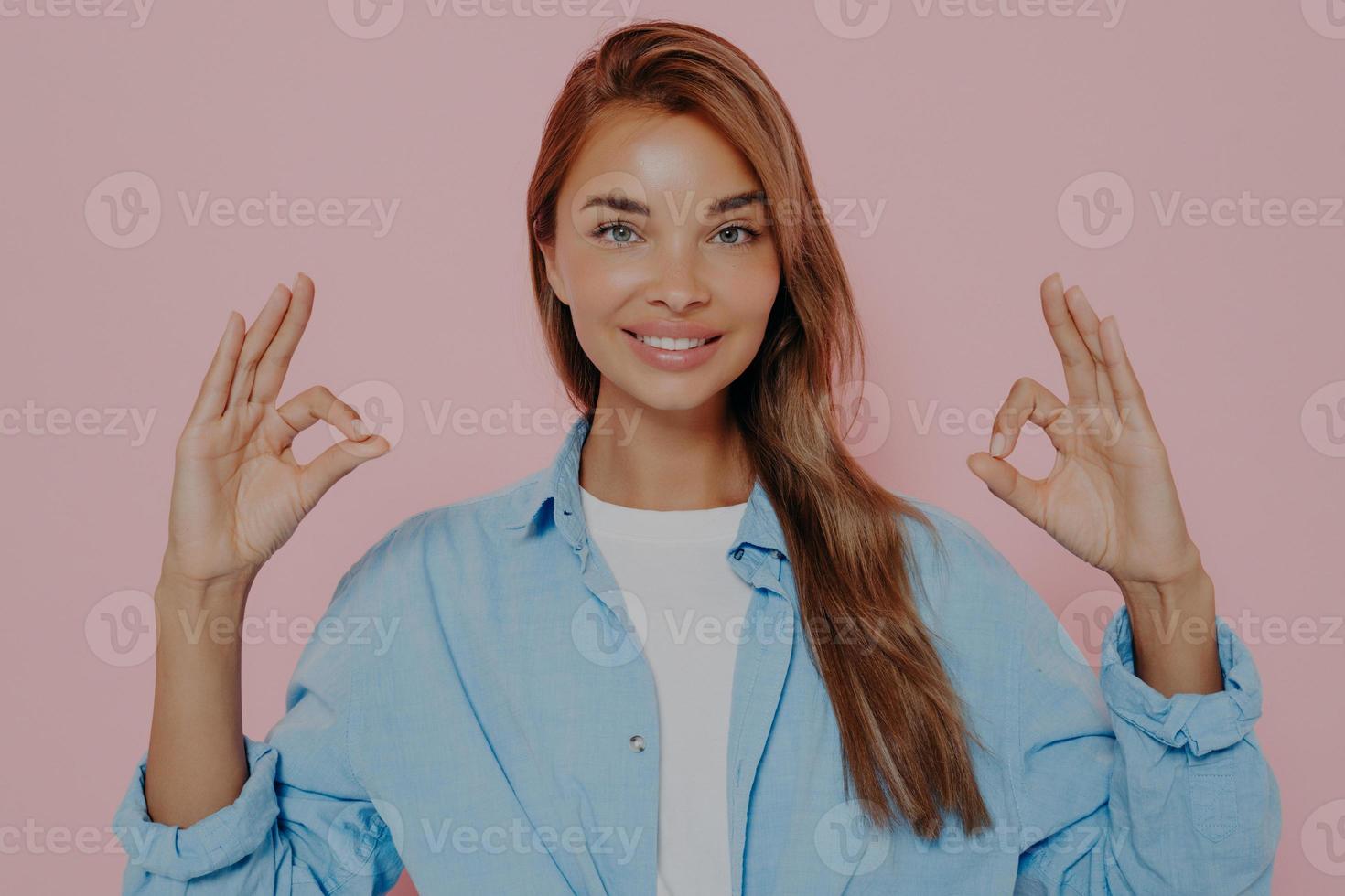 Beautiful woman showing okay gesture with both hands photo