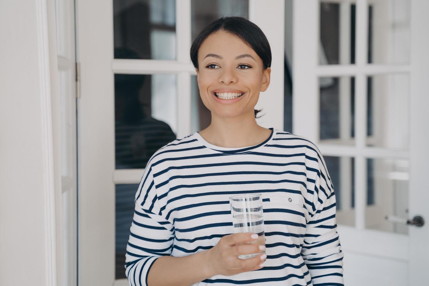 Happy female holding glass of clean water. Healthy lifestyle, wellness. Water filter advertising photo