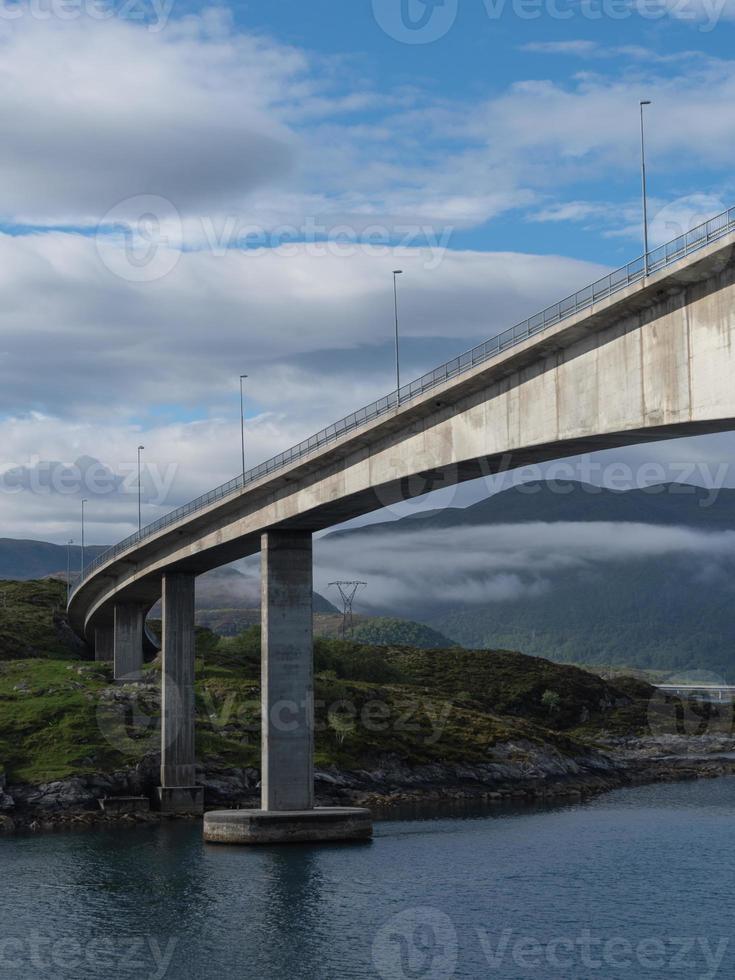 un puente en el norte de noruega, que conecta un paisaje roto por el agua. foto