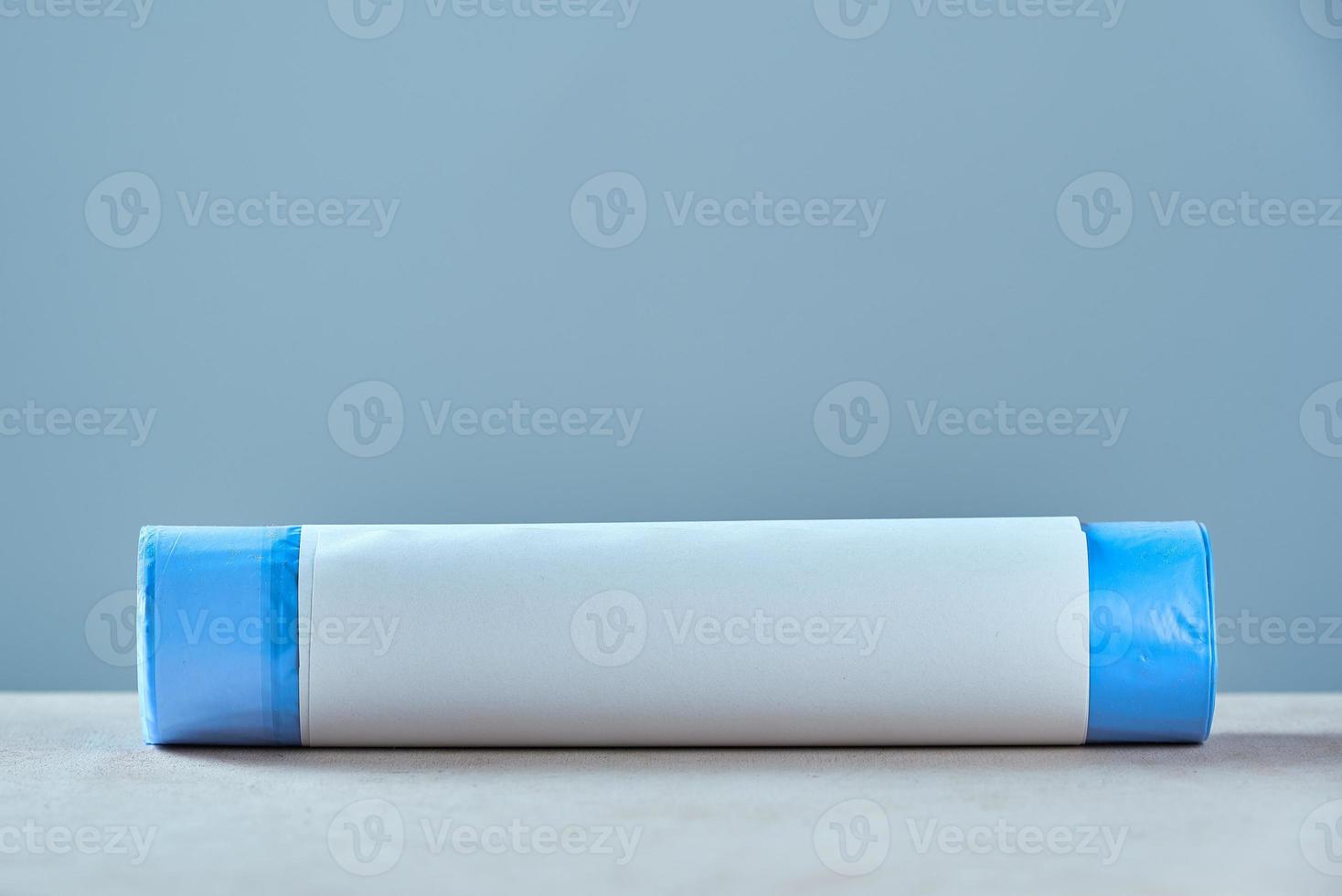 Roll blue garbage bags with copy space on grey background. photo