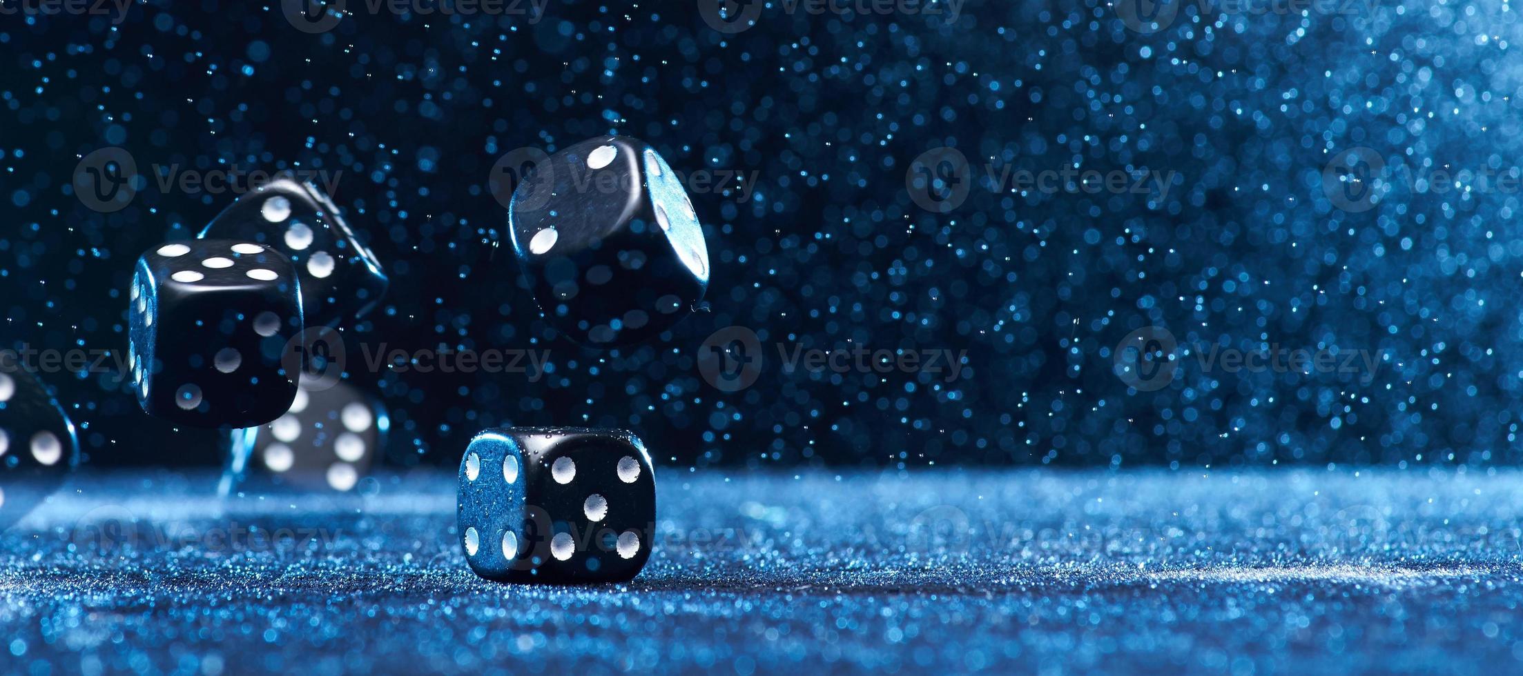 Several black cubes falling on a blue background. Photo with copy space.