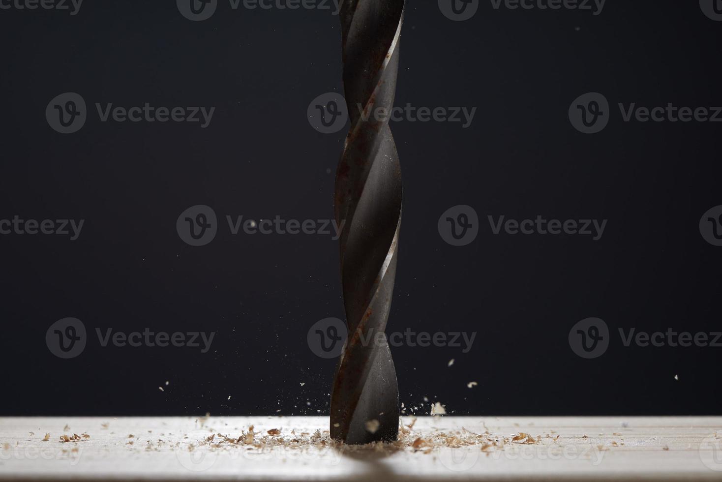 Wood drill bit with shaving on a gray background. Photo with copy space. Background in blur.