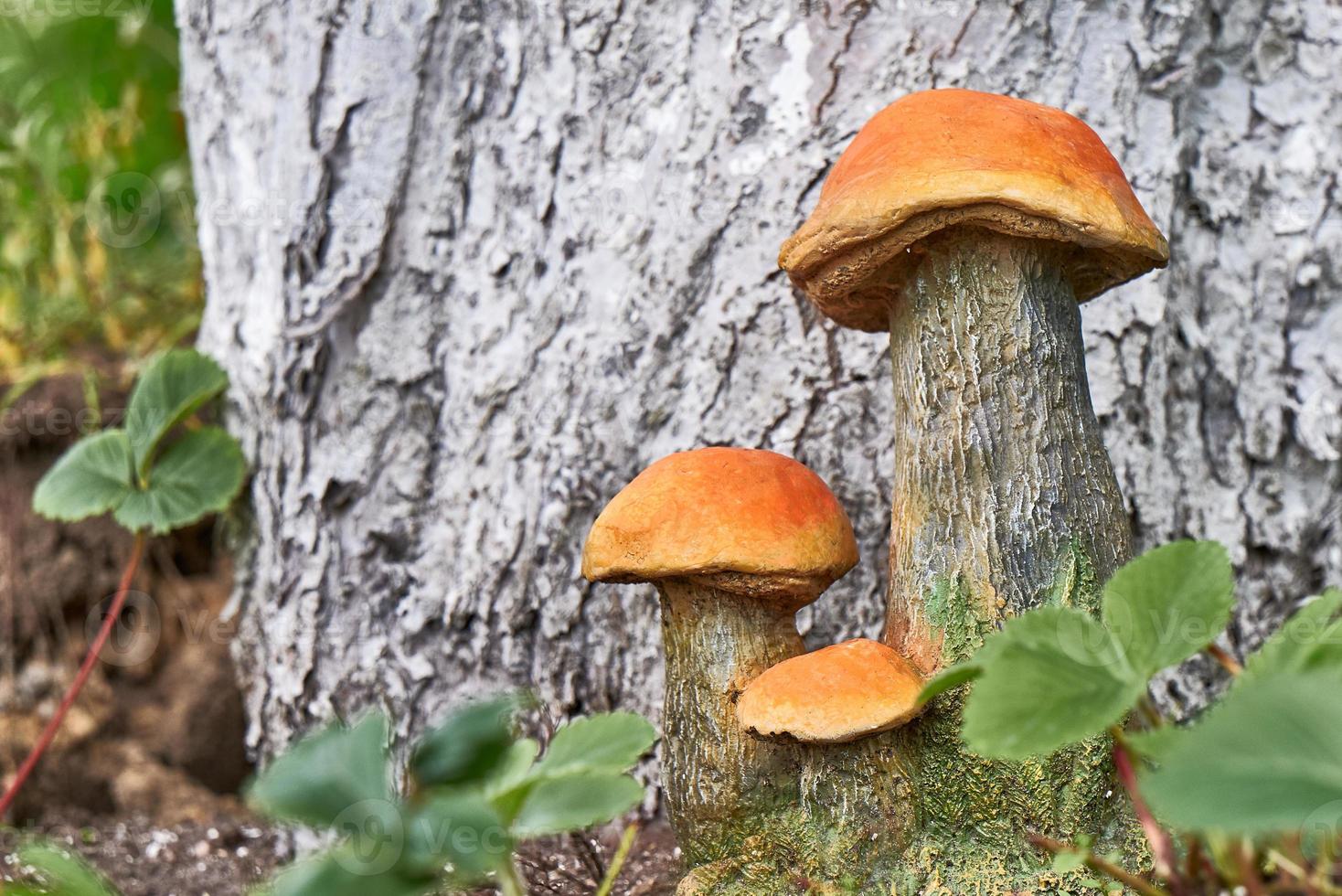 Garden statues mushrooms on the background of a tree trunk. Garden design. photo