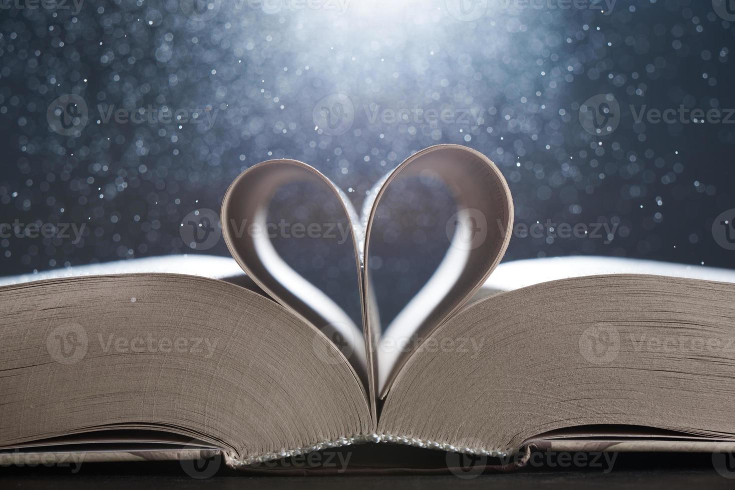 The magical world of reading magic book with pages transforming into heart. The background in blur. photo