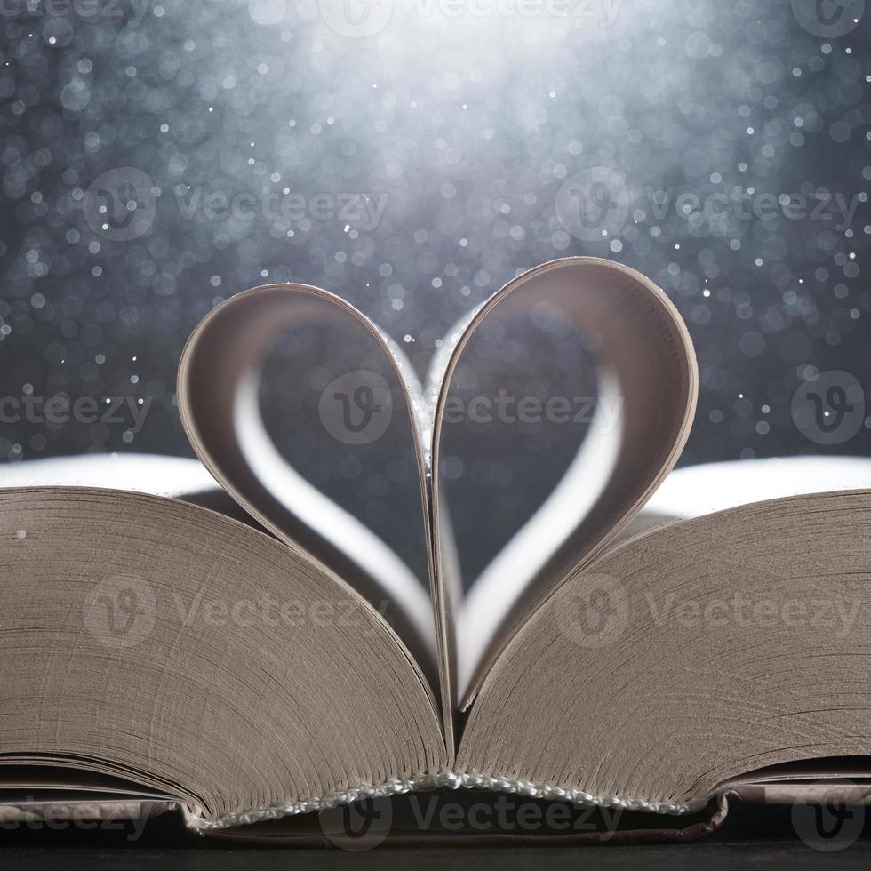 The magical world of reading magic book with pages transforming into heart. The background in blur. photo