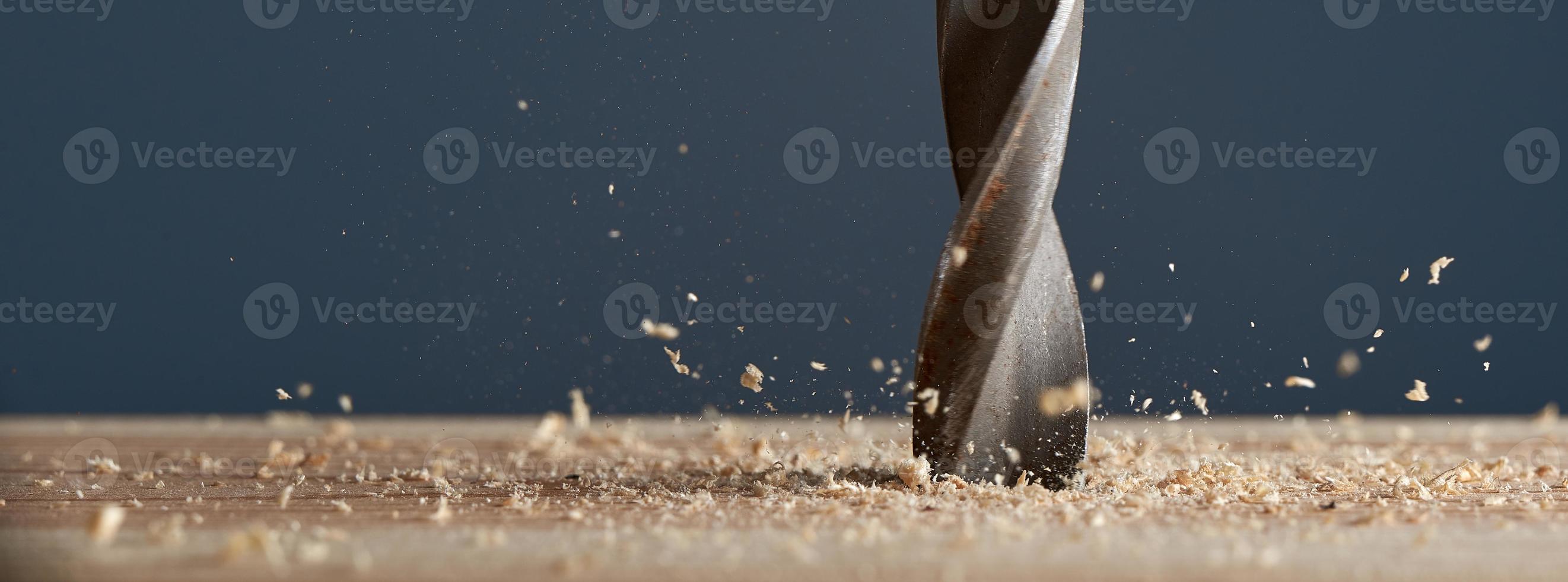 Wood drill bit in the blur with shaving on a gray background. Photo with copy space.