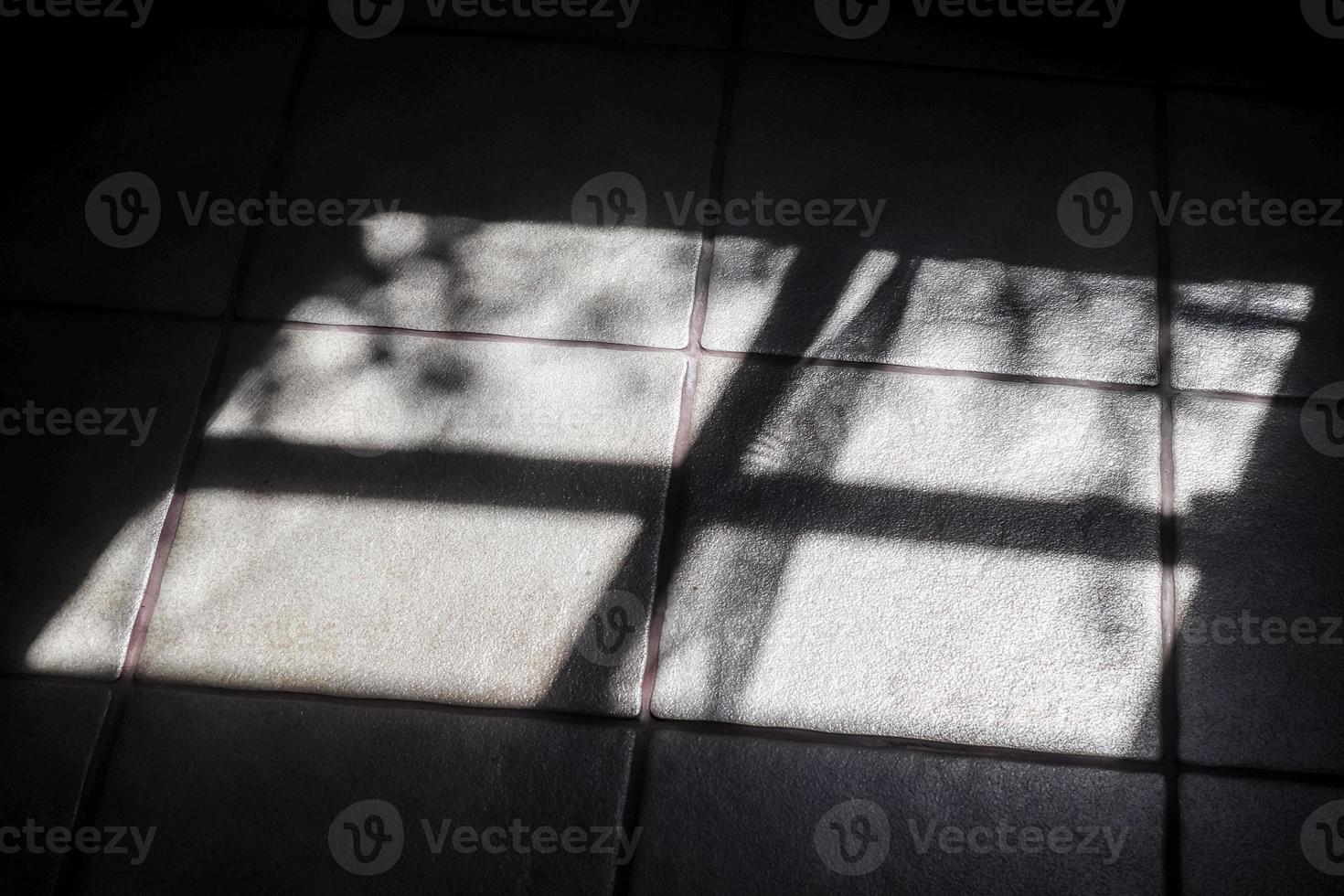 Abstract concept of soft shadows of the sunlight through a window on a tile background photo