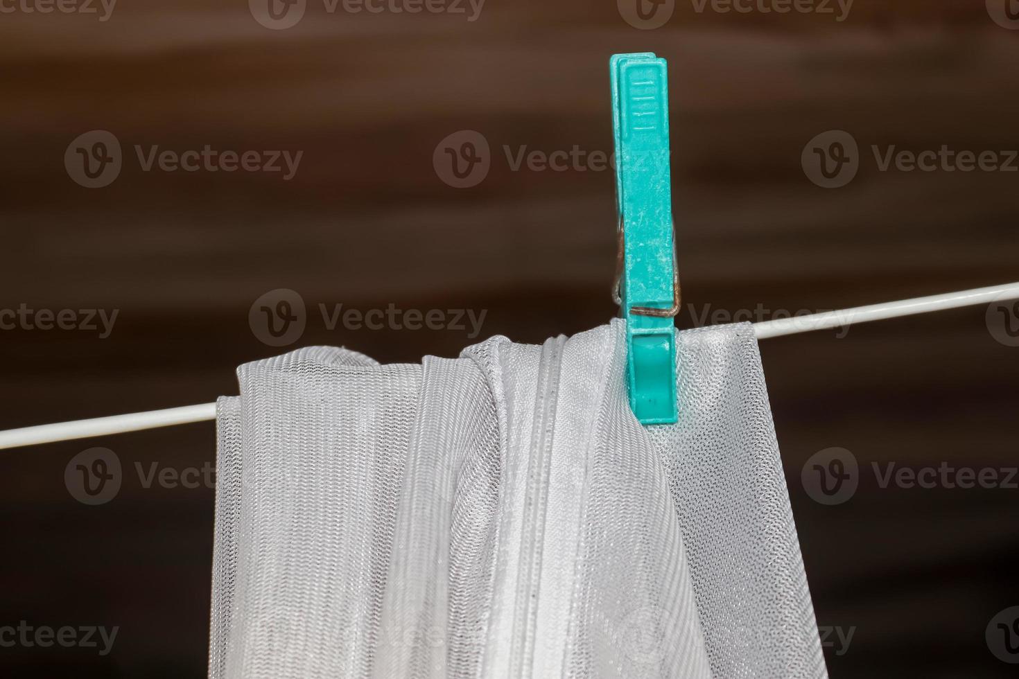 Clothes hung out to dry on a washing line and fastened by the clothes pegs photo