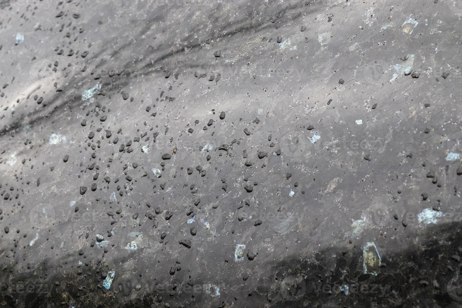 Rain drops on a black metallic car surface in a closeup view. photo