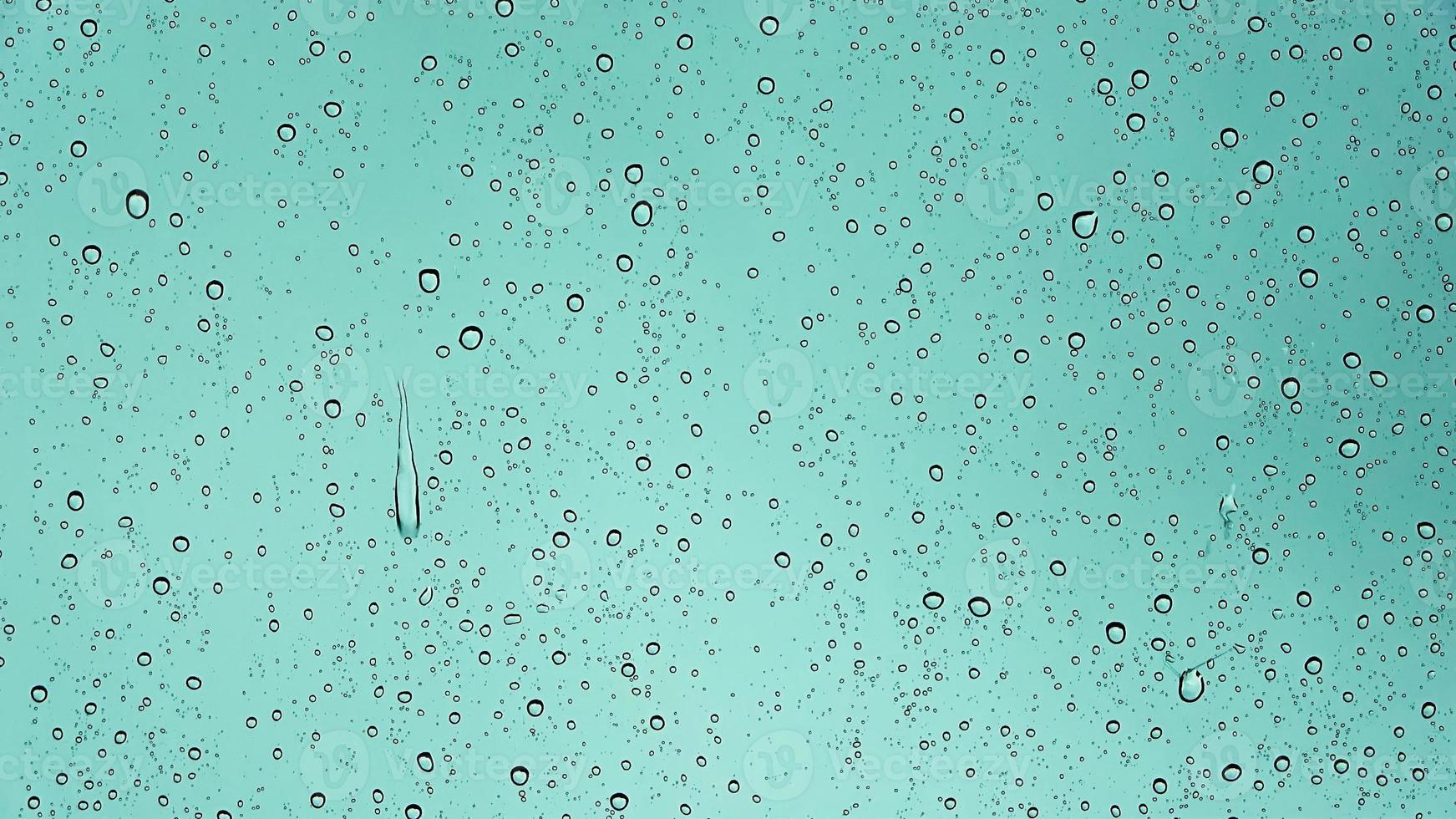 Rain drops running down a car window in a close up view. photo