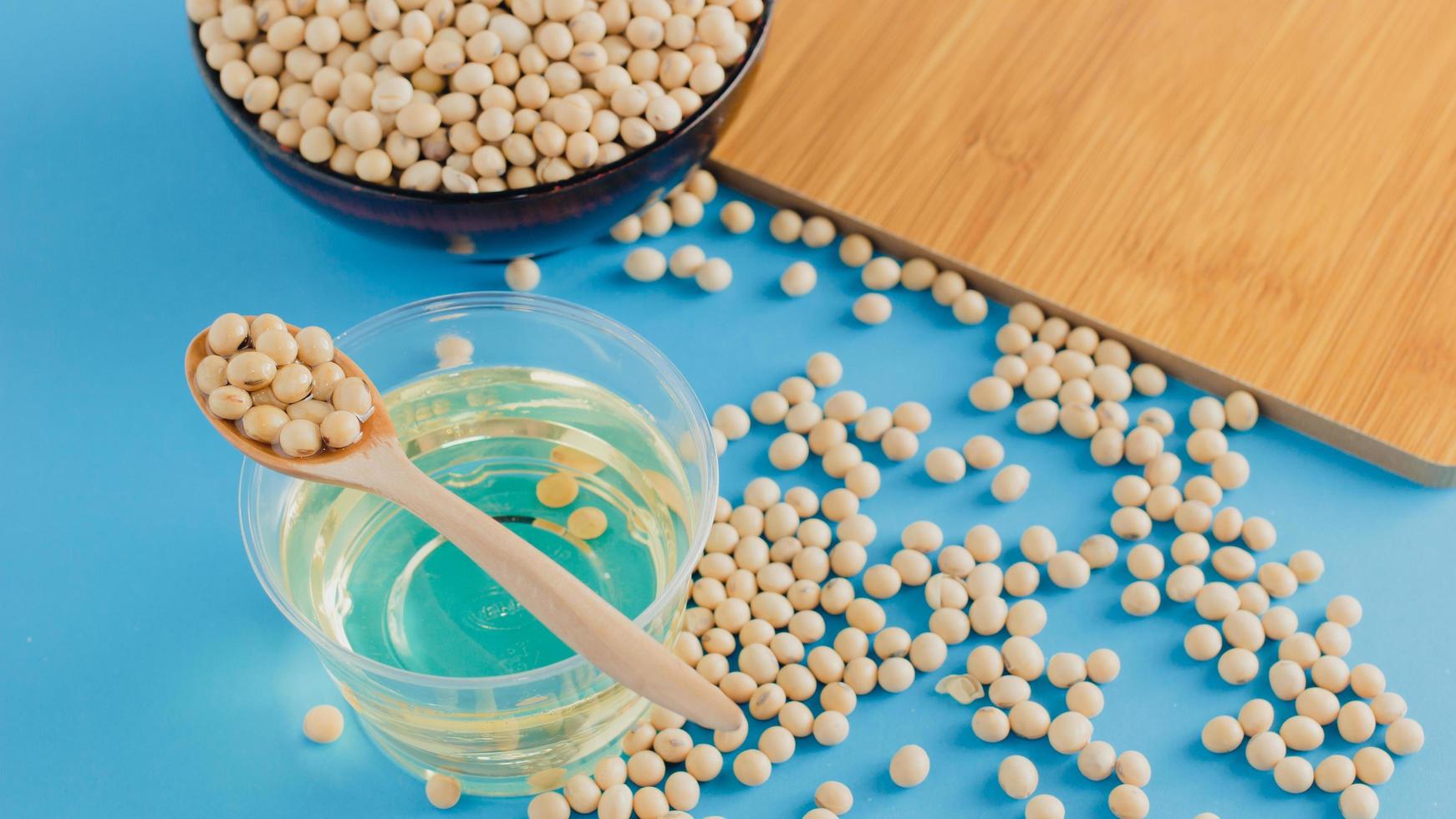 soybean and oil in a bowl on blue background, selective focus.copy