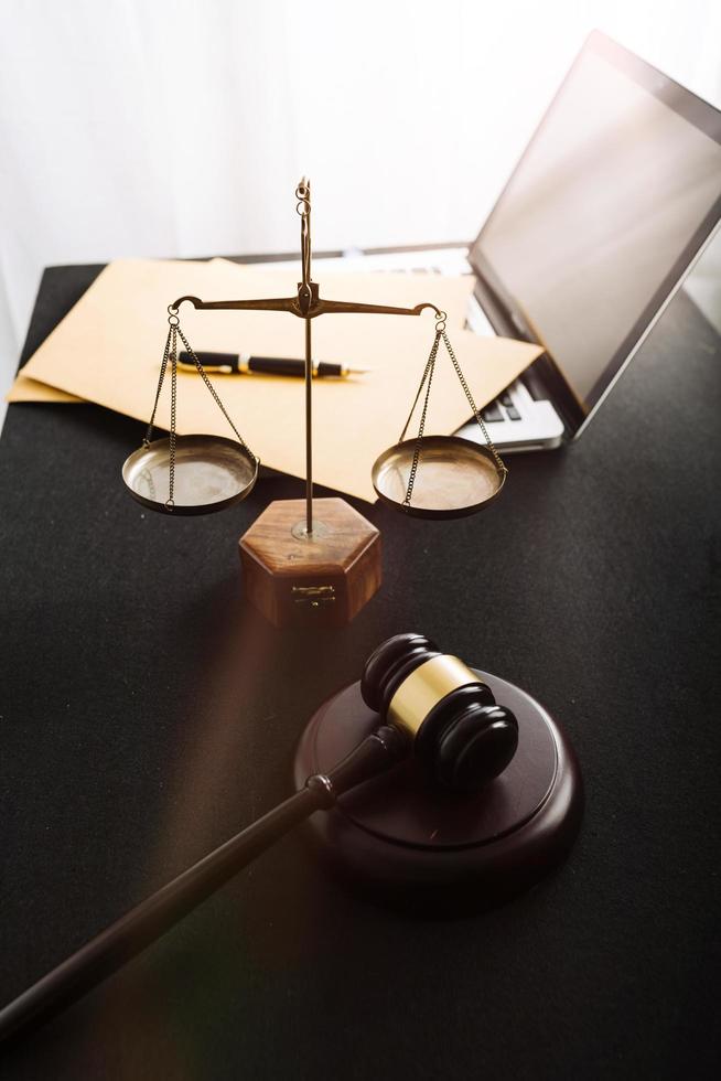 Business and lawyers discussing contract papers with brass scale on desk in office. Law, legal services, advice, justice and law concept picture with film grain effect photo