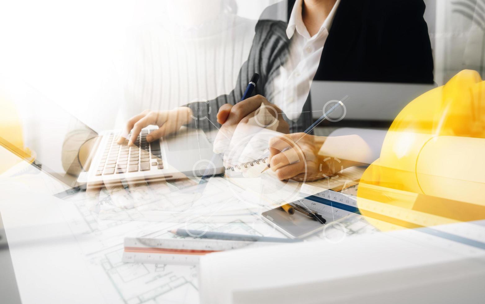 business hand working and laptop with on on architectural project at construction site at office desk in office photo