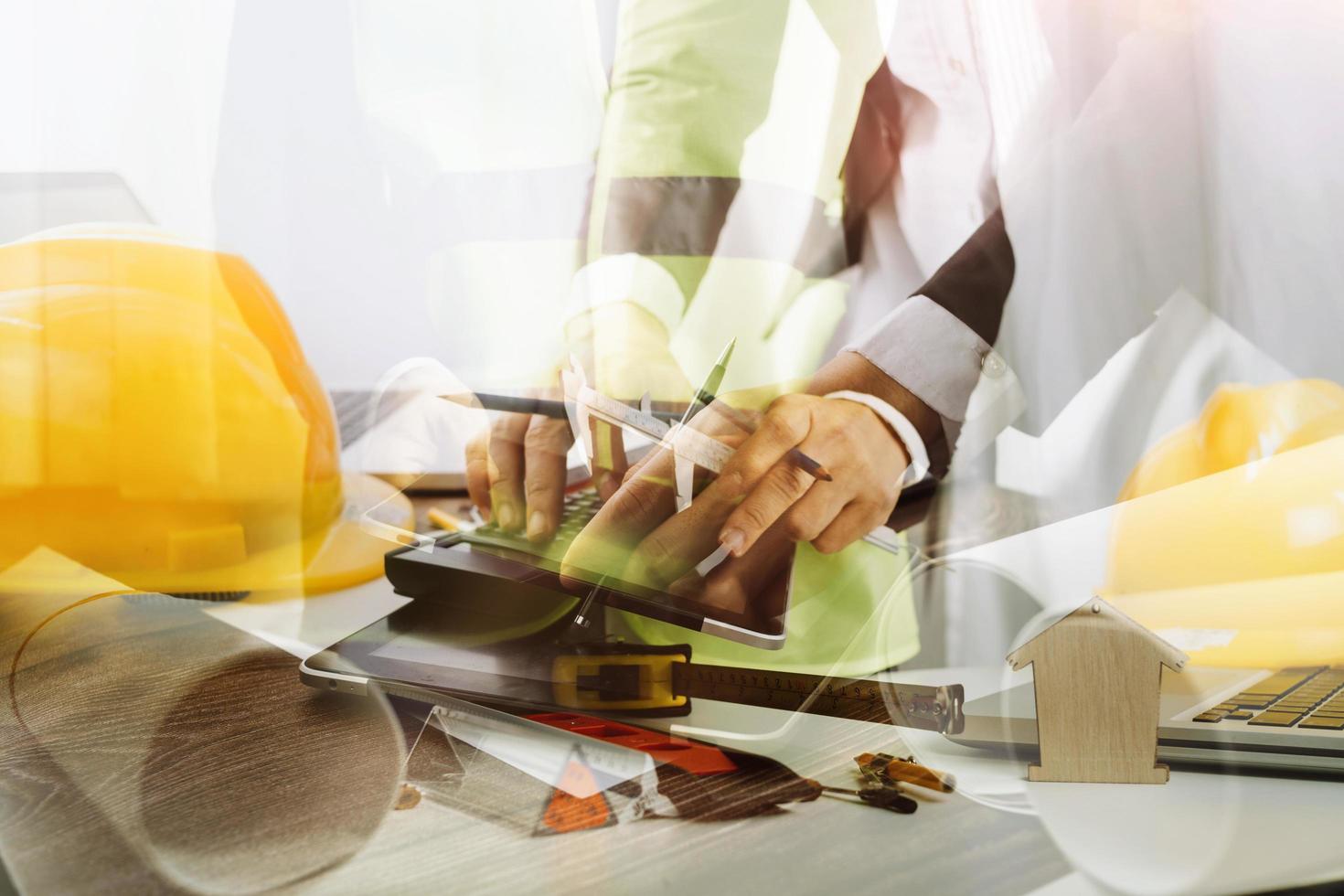 business hand working and laptop with on on architectural project at construction site at office desk in office photo