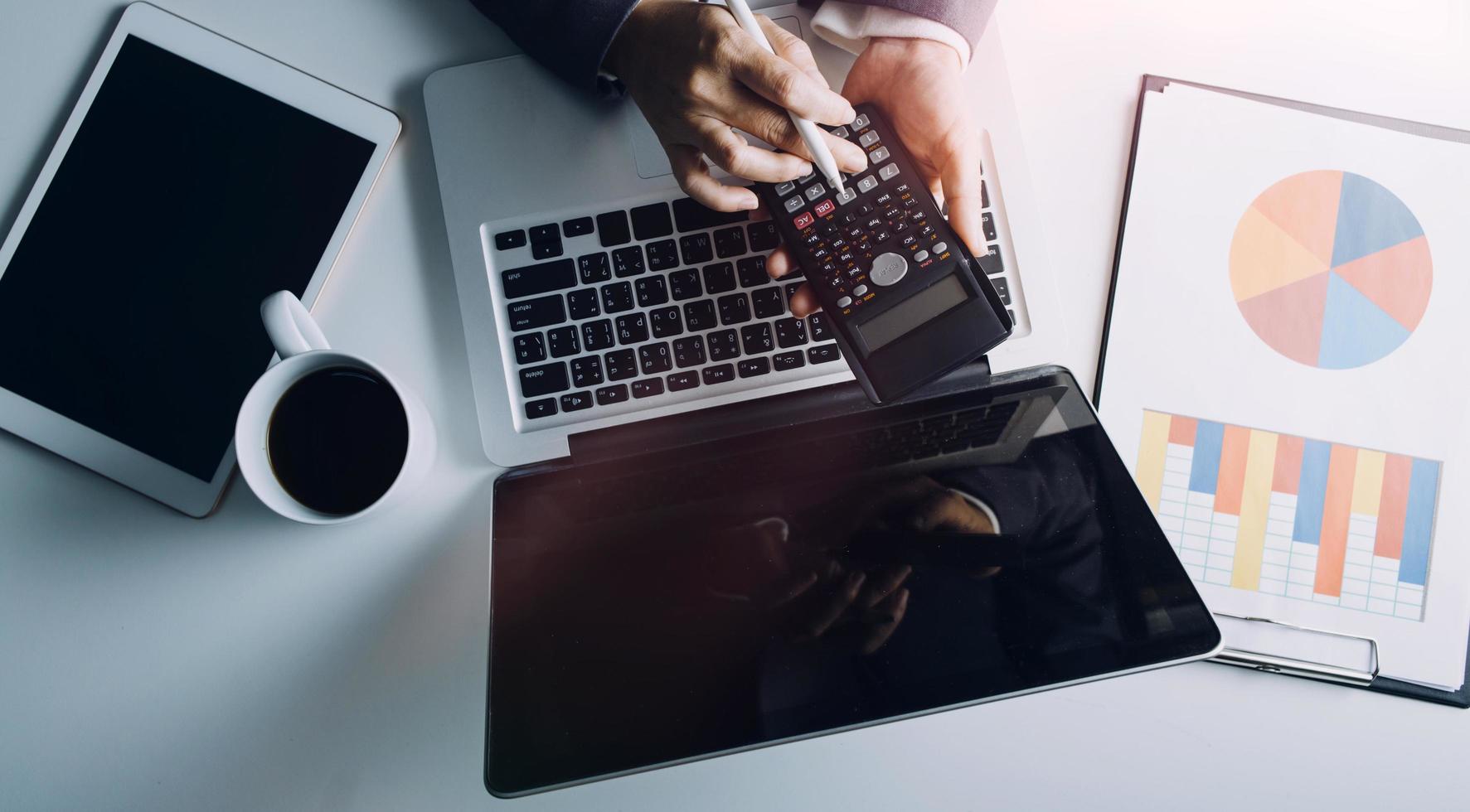 Business accounting concept, Business man using calculator with computer laptop, budget and loan paper in office. photo