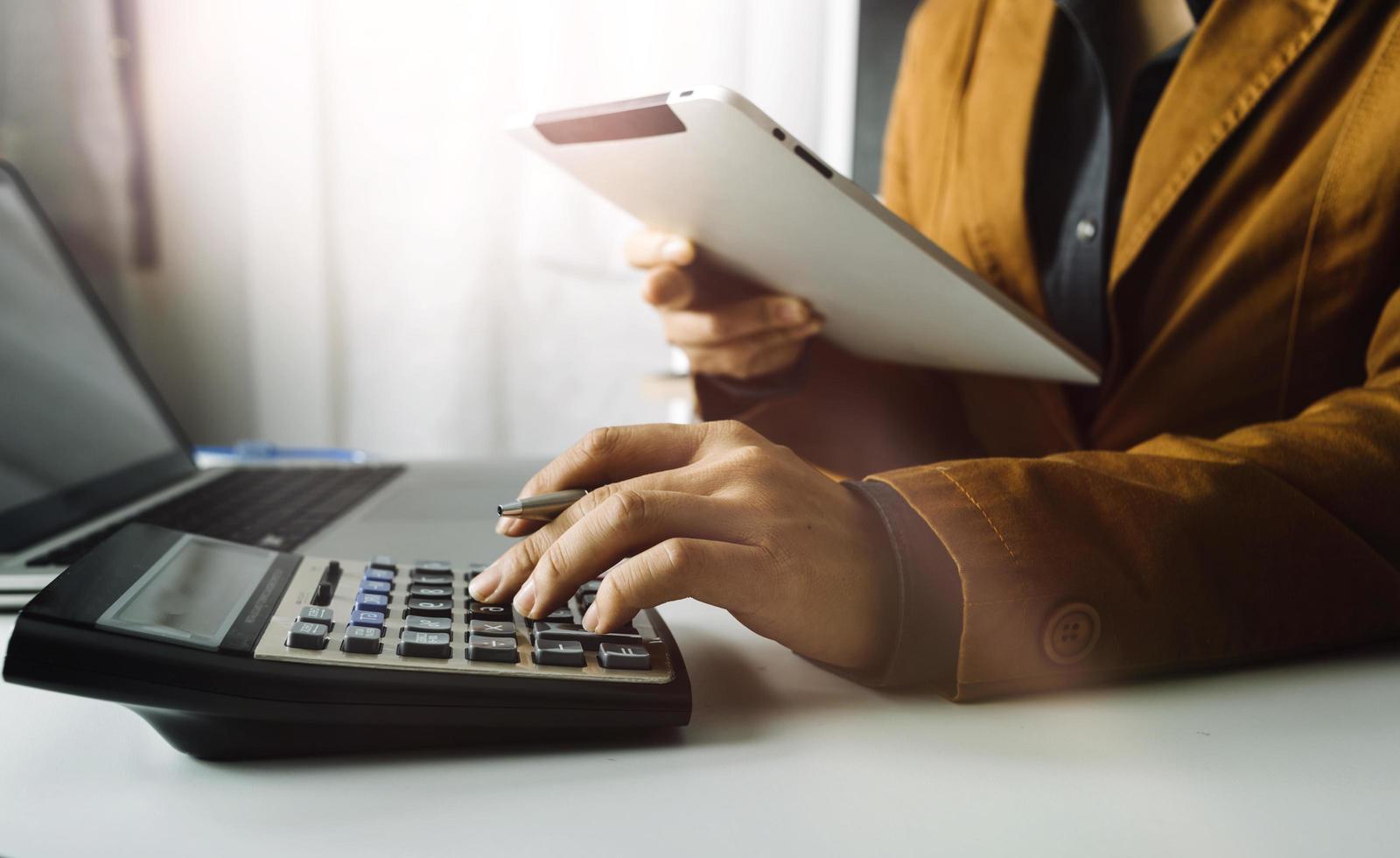 Business accounting concept, Business man using calculator with computer laptop, budget and loan paper in office. photo