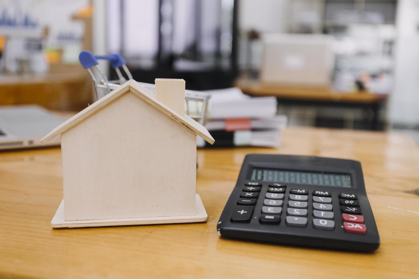 Modeling wooden houses and coins and dollars placed on wooden tables,preparation concept for house model purchase and the fastest growing real estate economy,moving home or renting property via agent photo