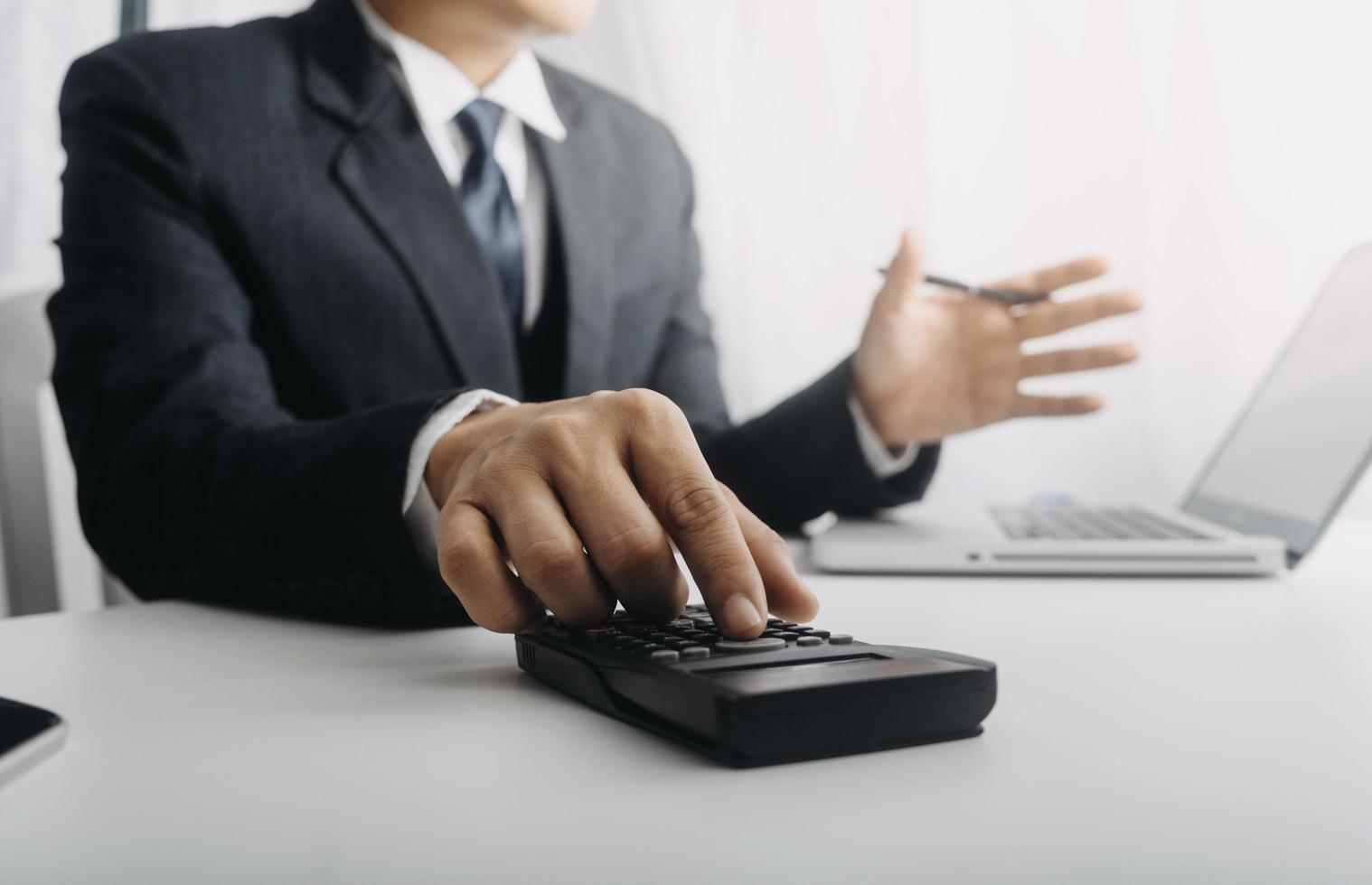 Business accounting concept, Business man using calculator with computer laptop, budget and loan paper in office. photo