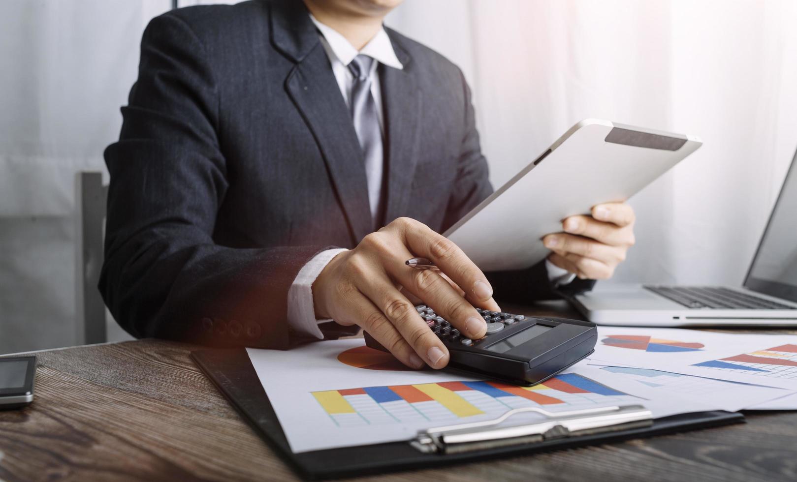 Business accounting concept, Business man using calculator with computer laptop, budget and loan paper in office. photo
