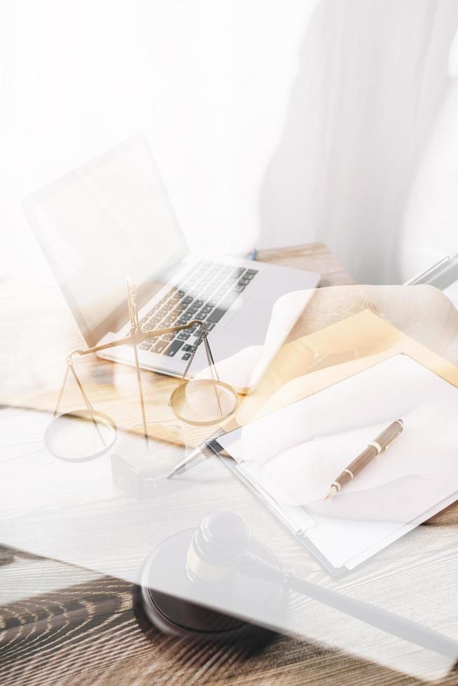 Justice and law concept.Male judge in a courtroom with the gavel, working with, computer and docking keyboard, eyeglasses, on table in morning light photo