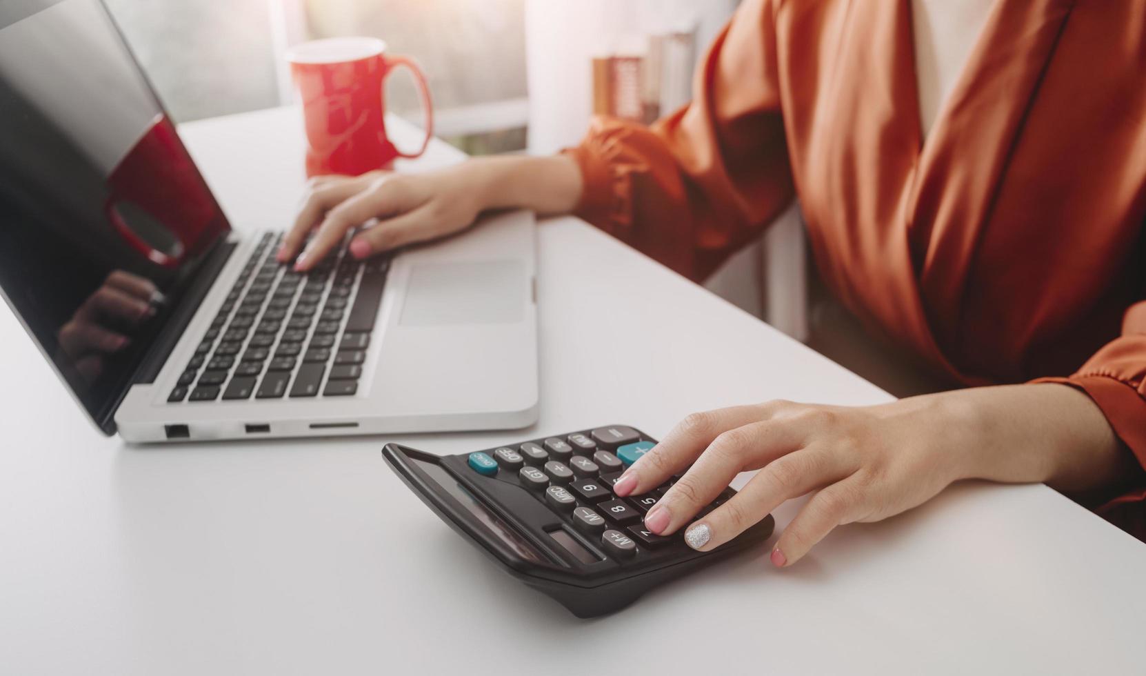 Business accounting concept, Business man using calculator with computer laptop, budget and loan paper in office. photo