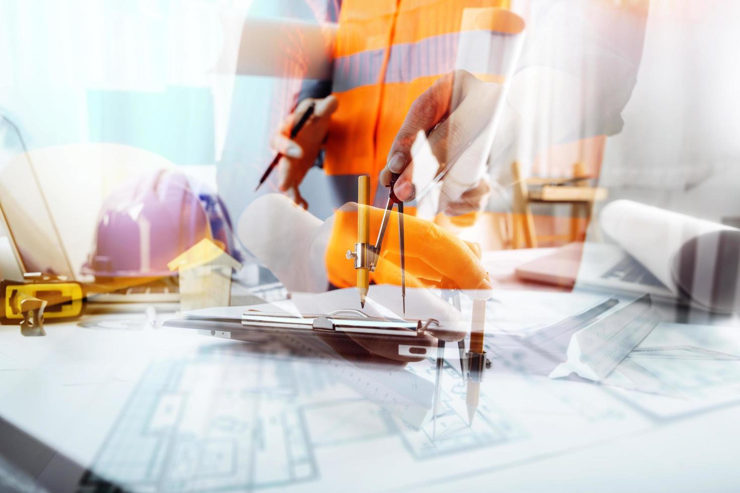 business hand working and laptop with on on architectural project at construction site at office desk in office photo
