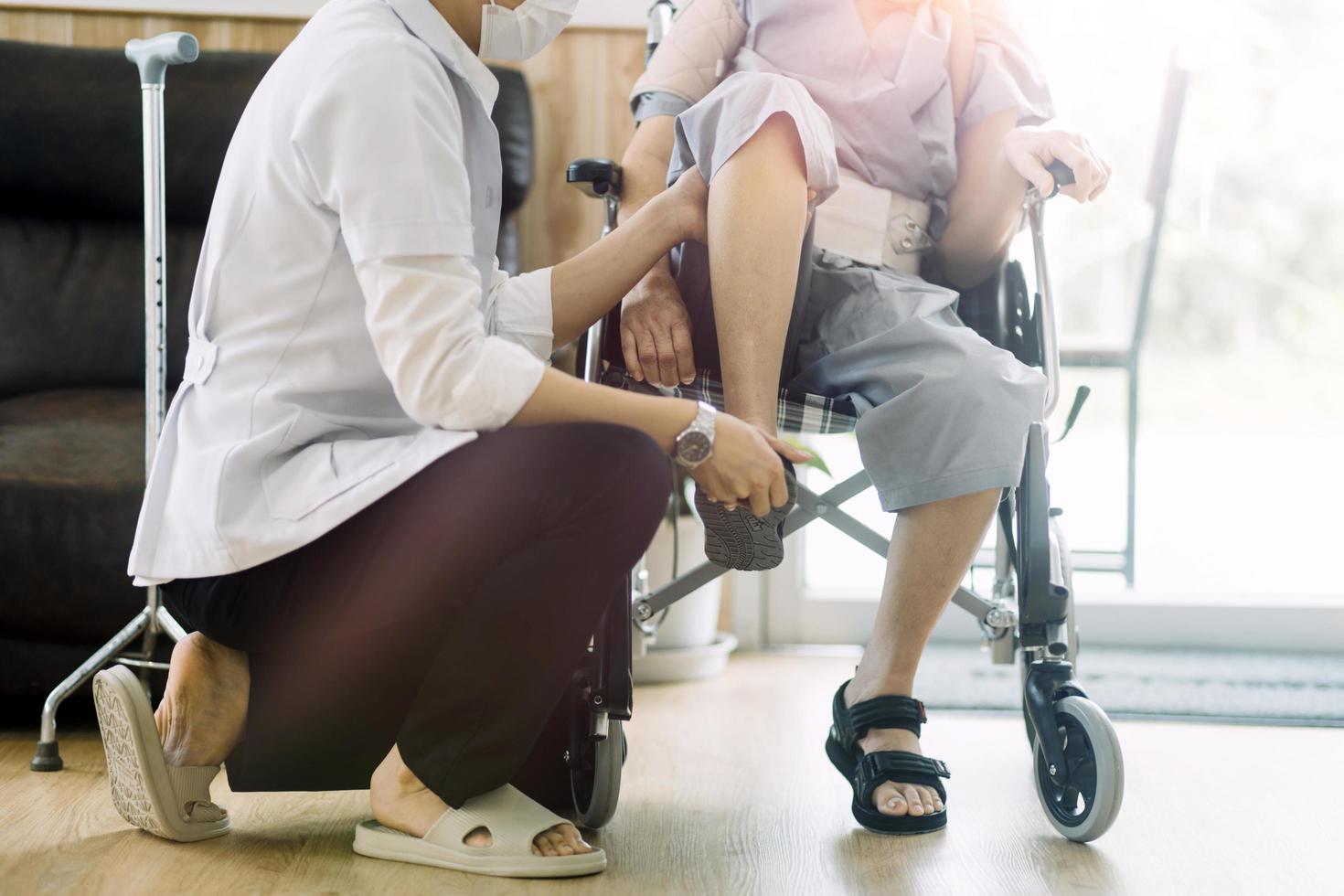 joven fisioterapeuta asiática que trabaja con una anciana caminando con un andador foto