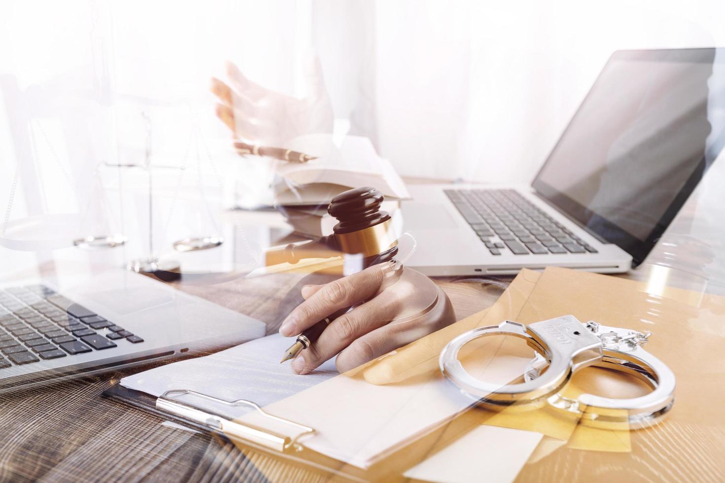 Justice and law concept.Male judge in a courtroom with the gavel, working with, computer and docking keyboard, eyeglasses, on table in morning light photo