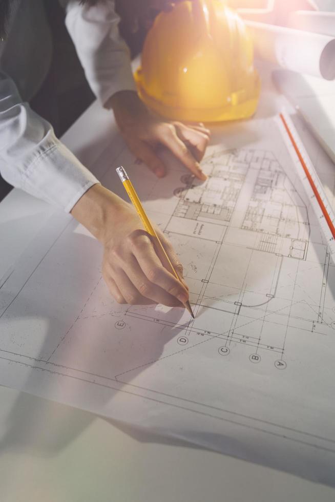 business hand working and laptop with on on architectural project at construction site at office desk in office photo