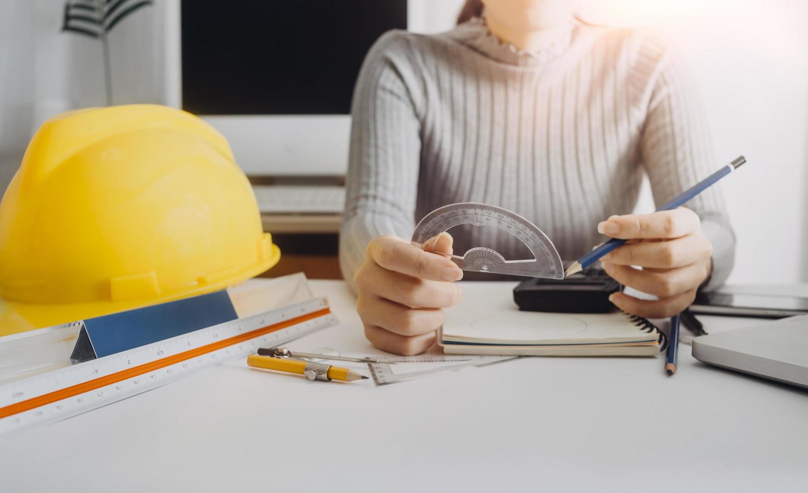 Two colleagues discussing data working and tablet, laptop with on on architectural project at construction site at desk in office photo