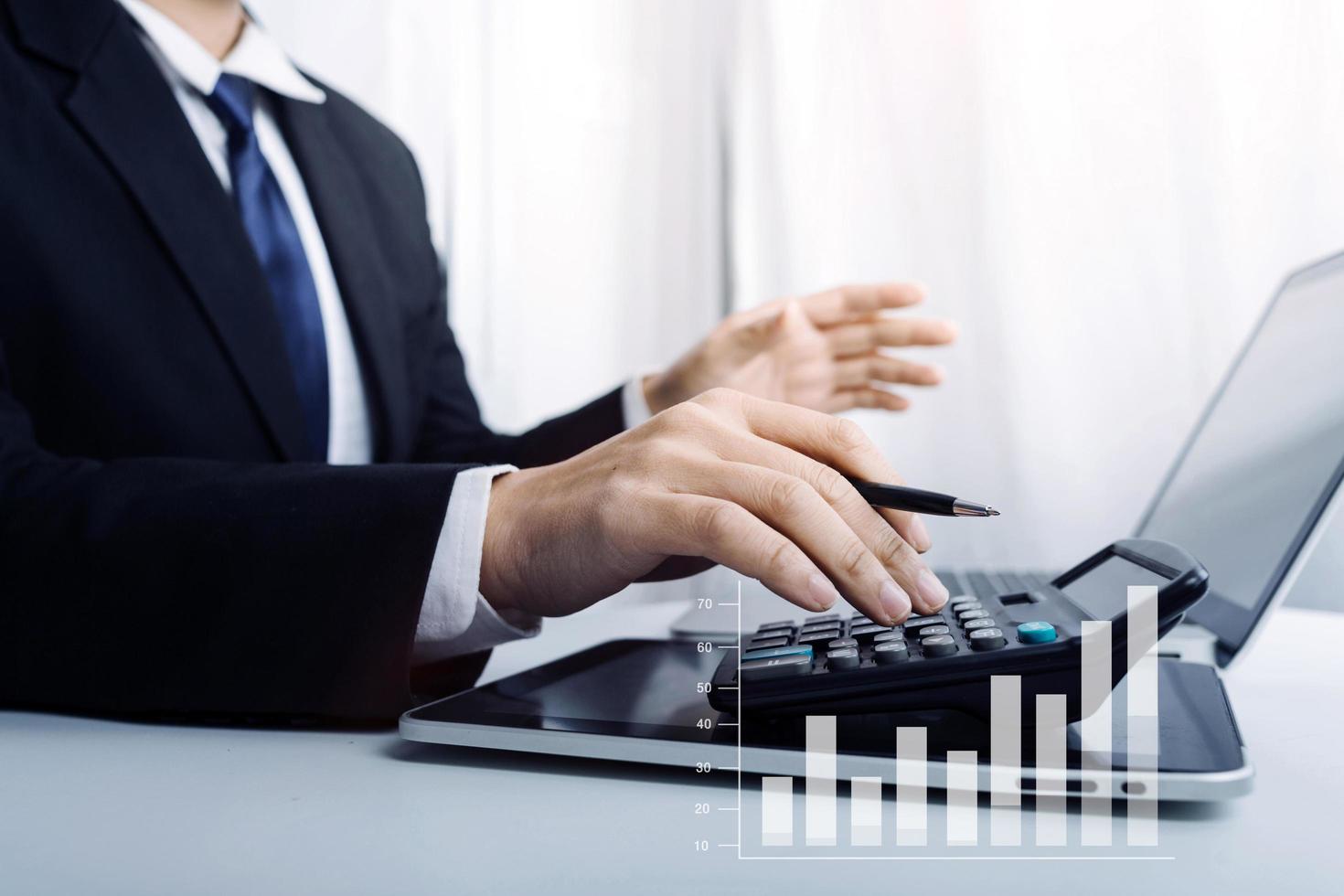 Business accounting concept, Business man using calculator with computer laptop, budget and loan paper in office. photo