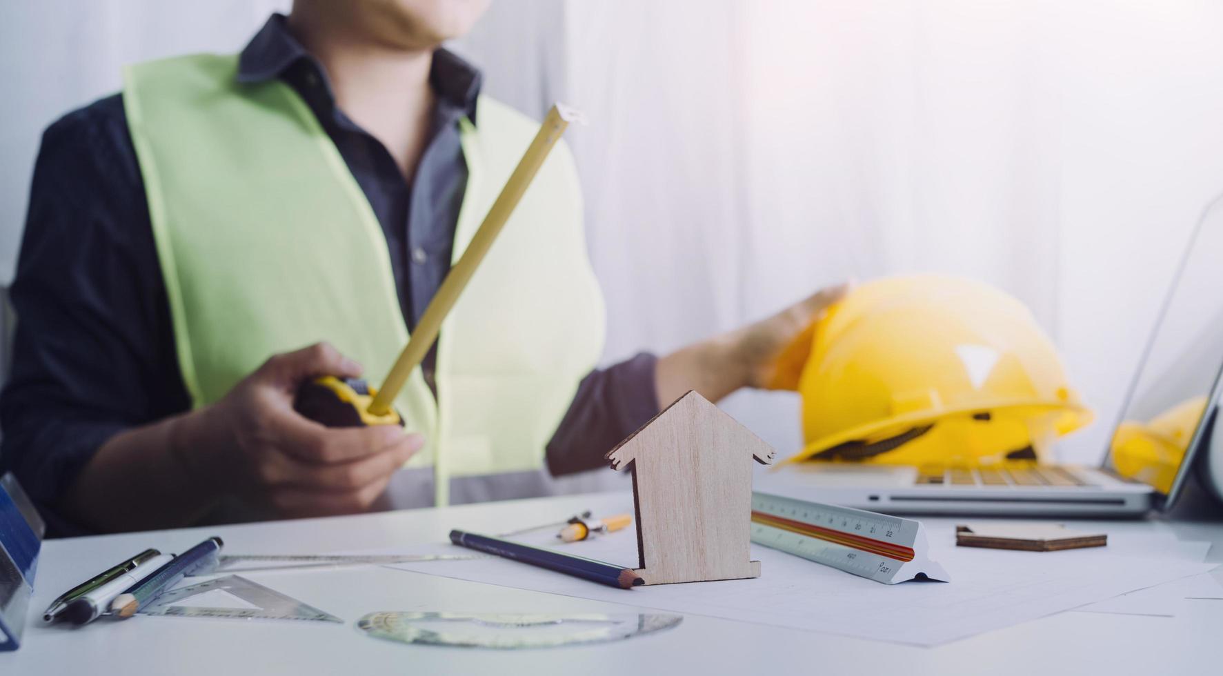 business hand working and laptop with on on architectural project at construction site at office desk in office photo
