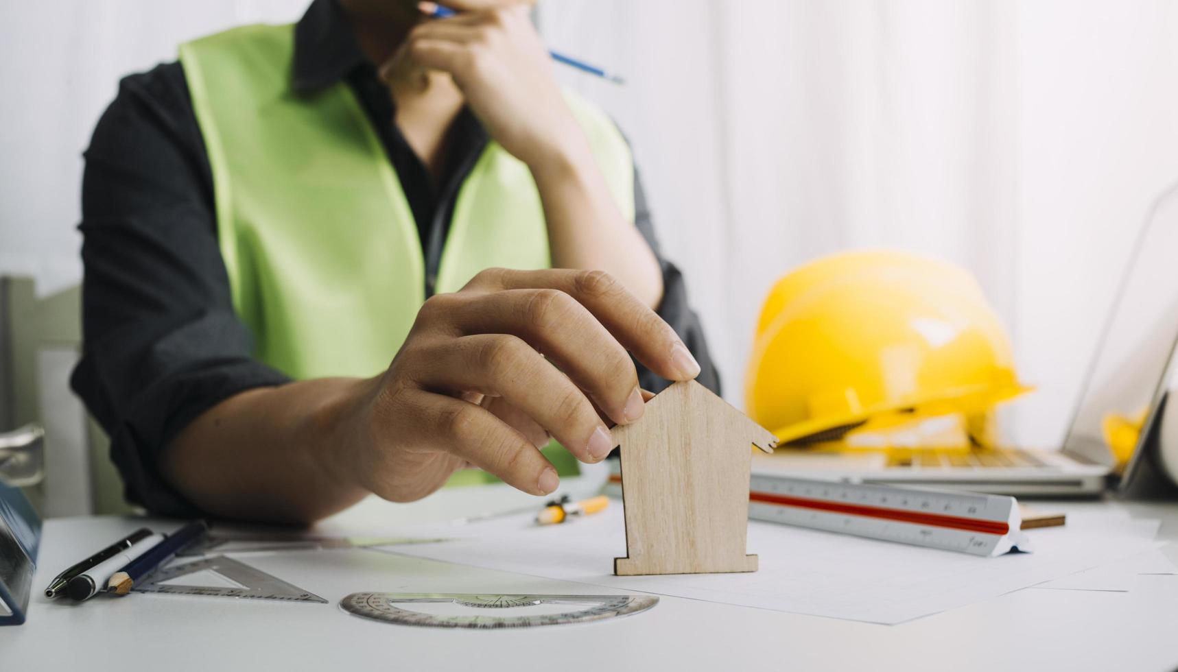 Dos colegas discutiendo el trabajo de datos y una tableta, un portátil con un proyecto arquitectónico en el sitio de construcción en un escritorio en la oficina foto