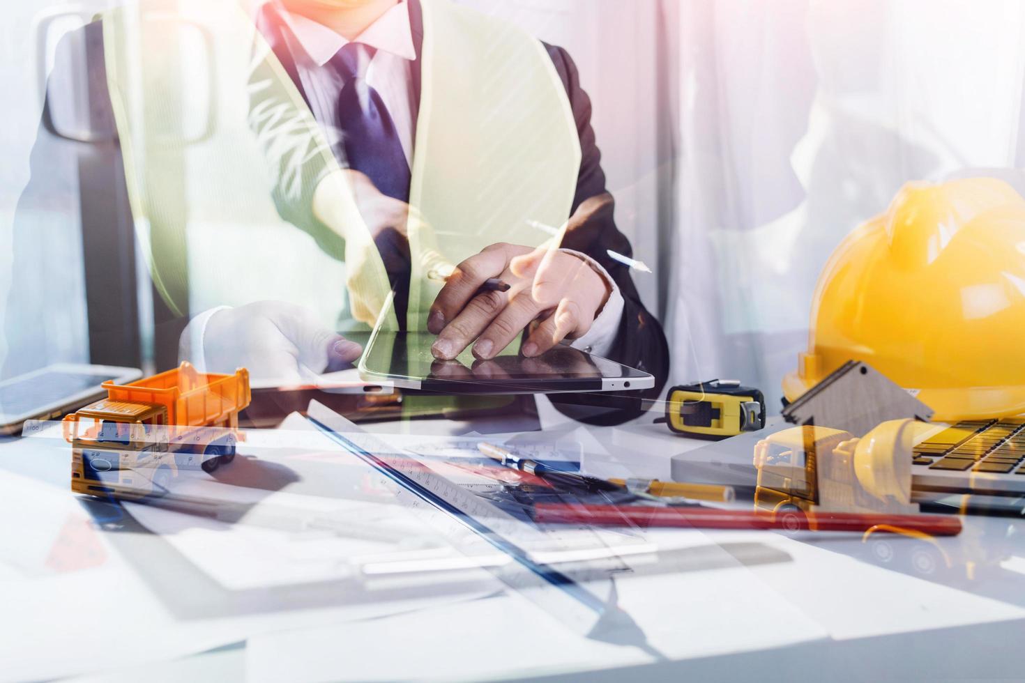 business hand working and laptop with on on architectural project at construction site at office desk in office photo