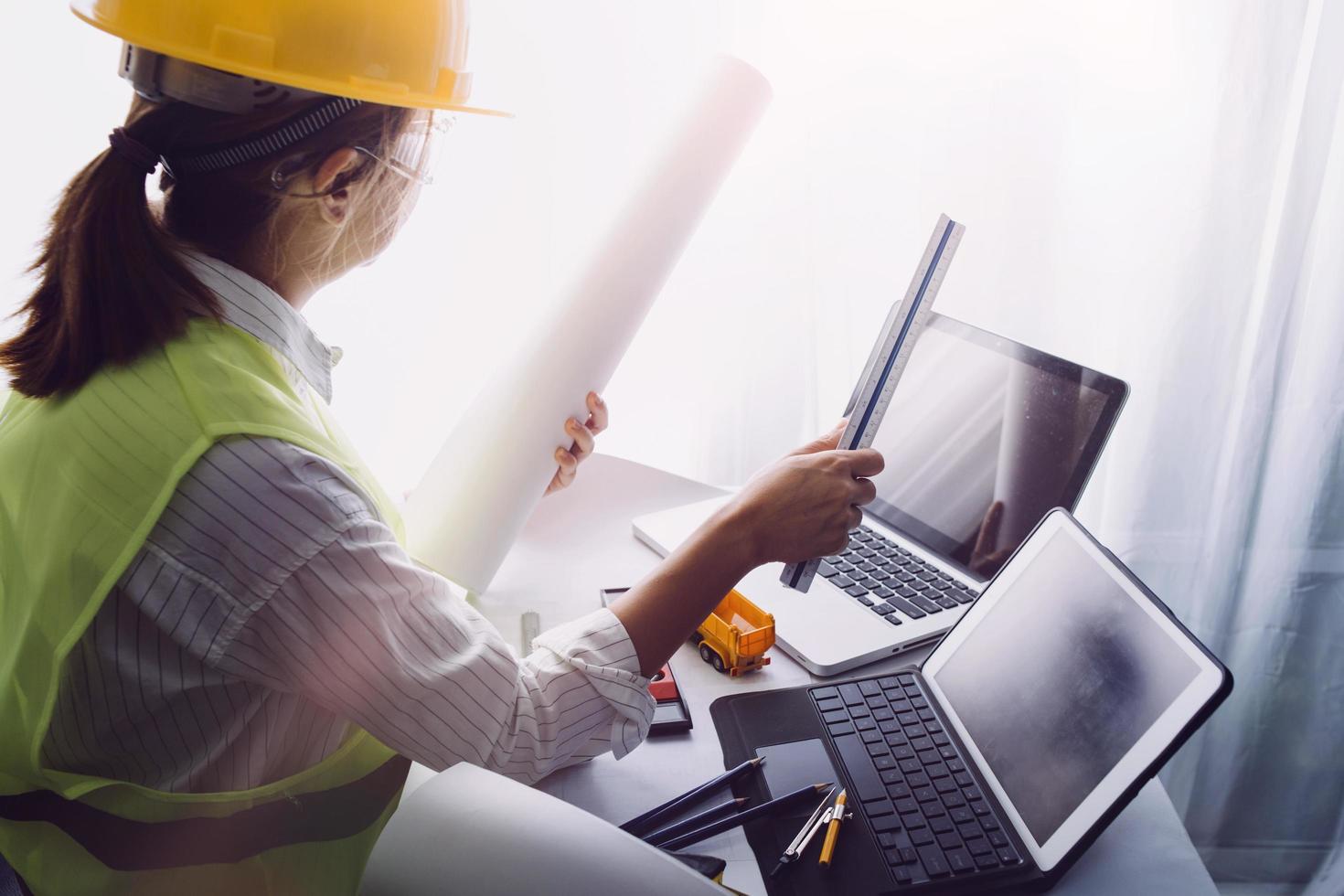 business hand working and laptop with on on architectural project at construction site at office desk in office photo