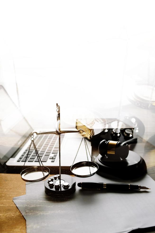 Justice and law concept.Male judge in a courtroom with the gavel, working with, computer and docking keyboard, eyeglasses, on table in morning light photo